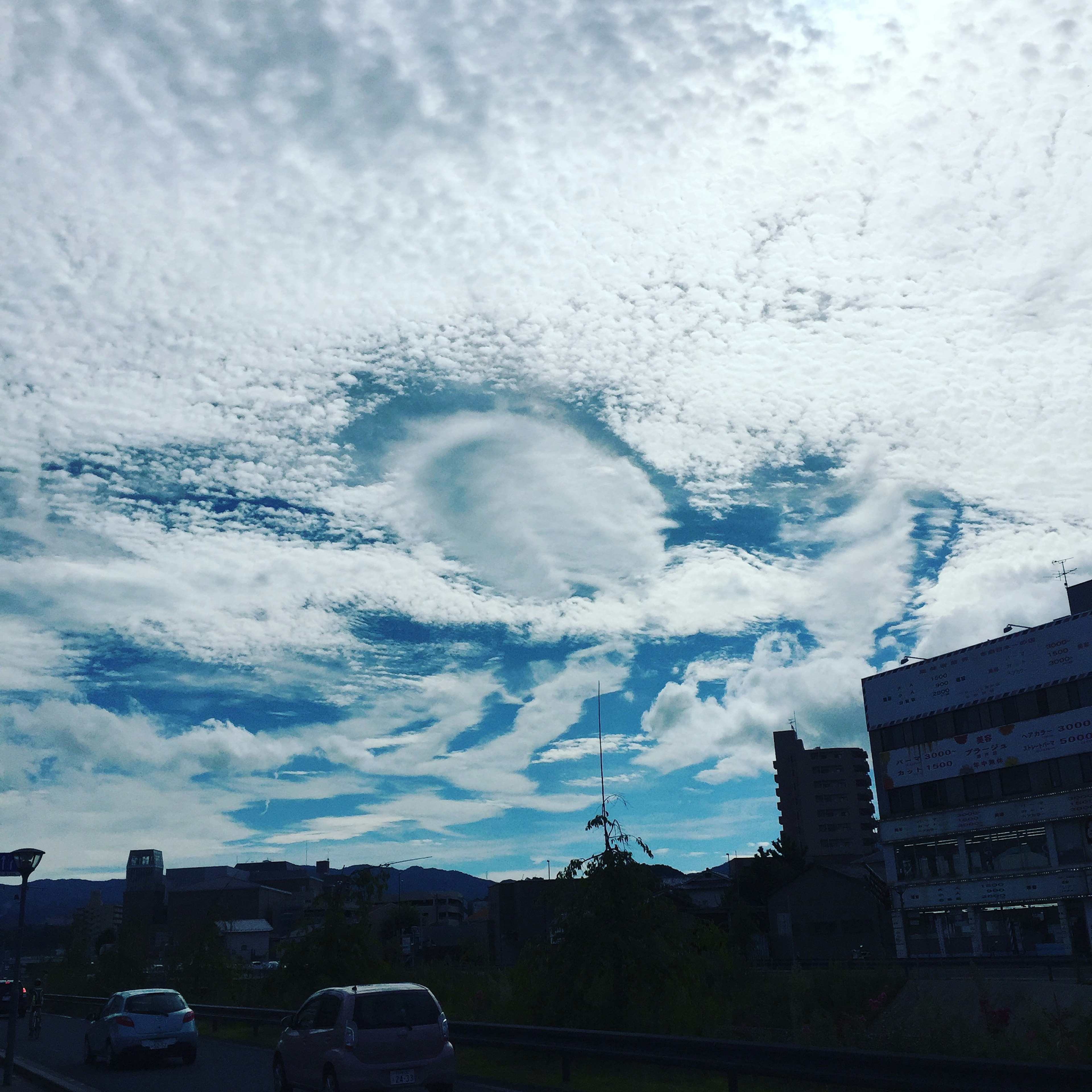 A landscape photo featuring a blue sky with unique cloud formations