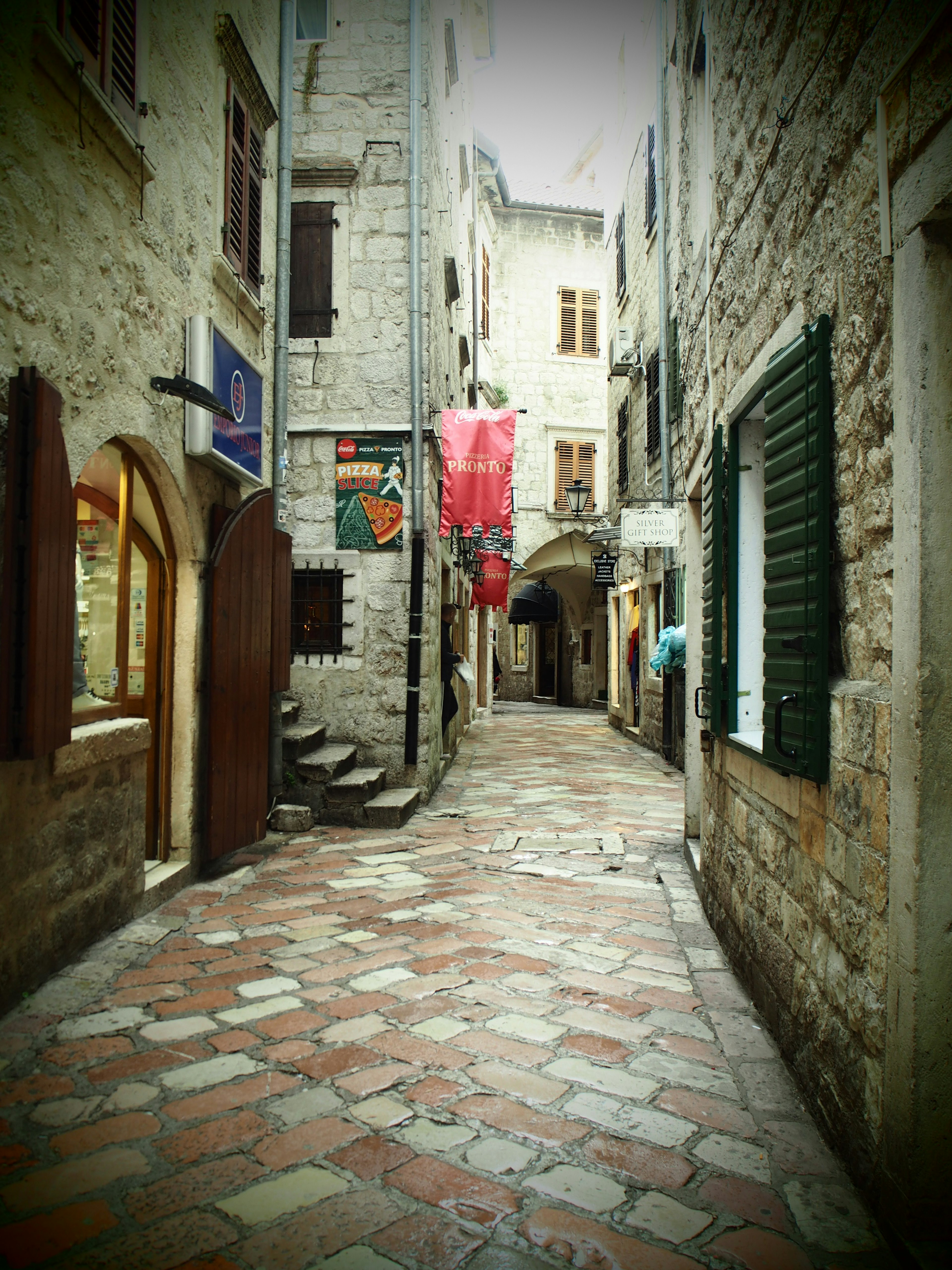 Callejón estrecho con edificios de piedra y pavimento de mosaico