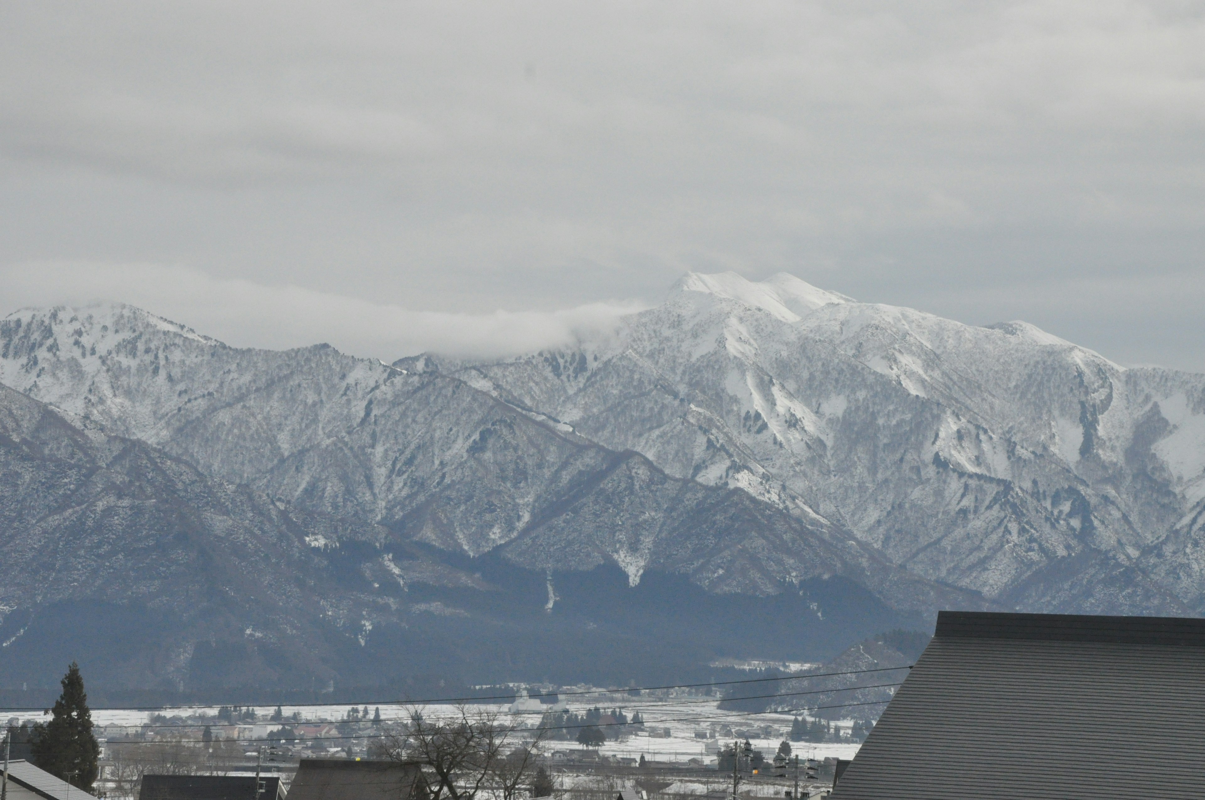 Snow-covered mountains under a gray sky