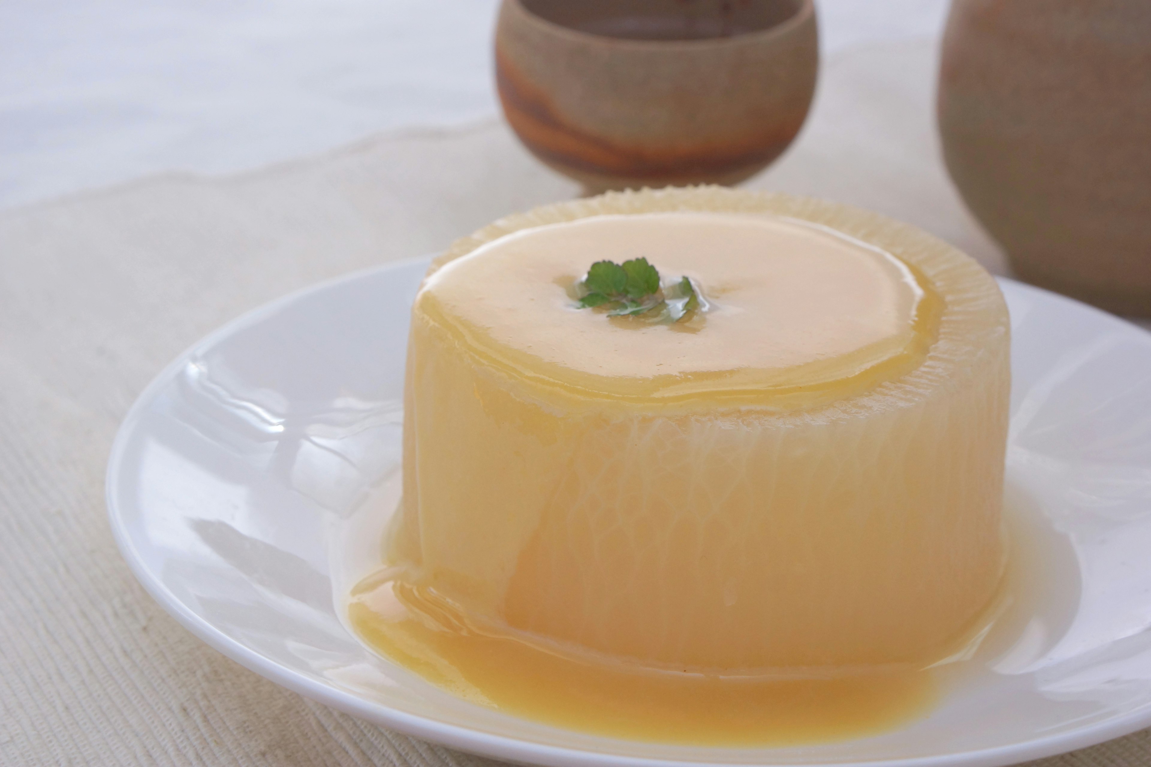 Un budino cremoso servito su un piatto guarnito con una foglia di menta