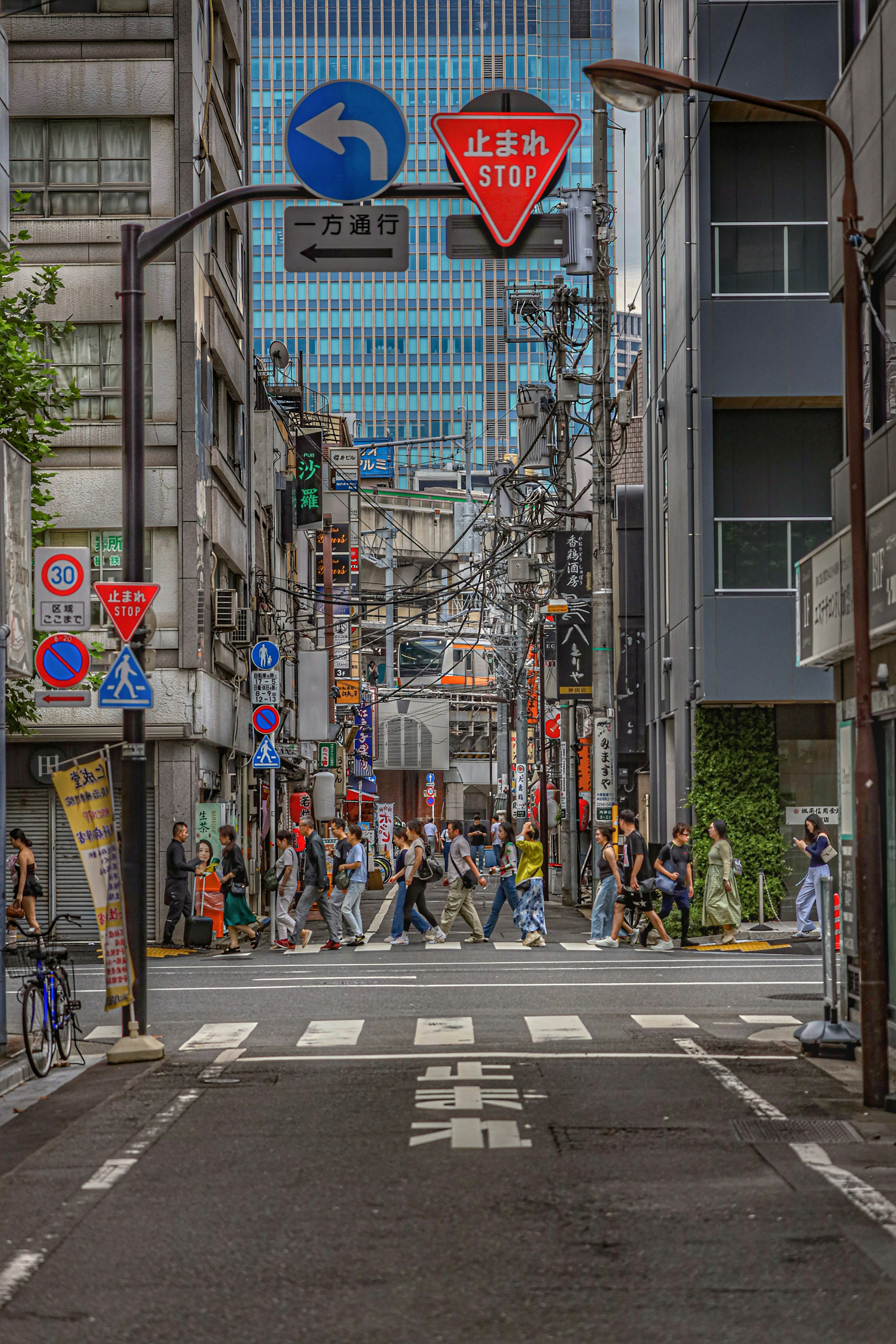 Incrocio urbano con persone che attraversano la strada segnali stradali e edifici visibili