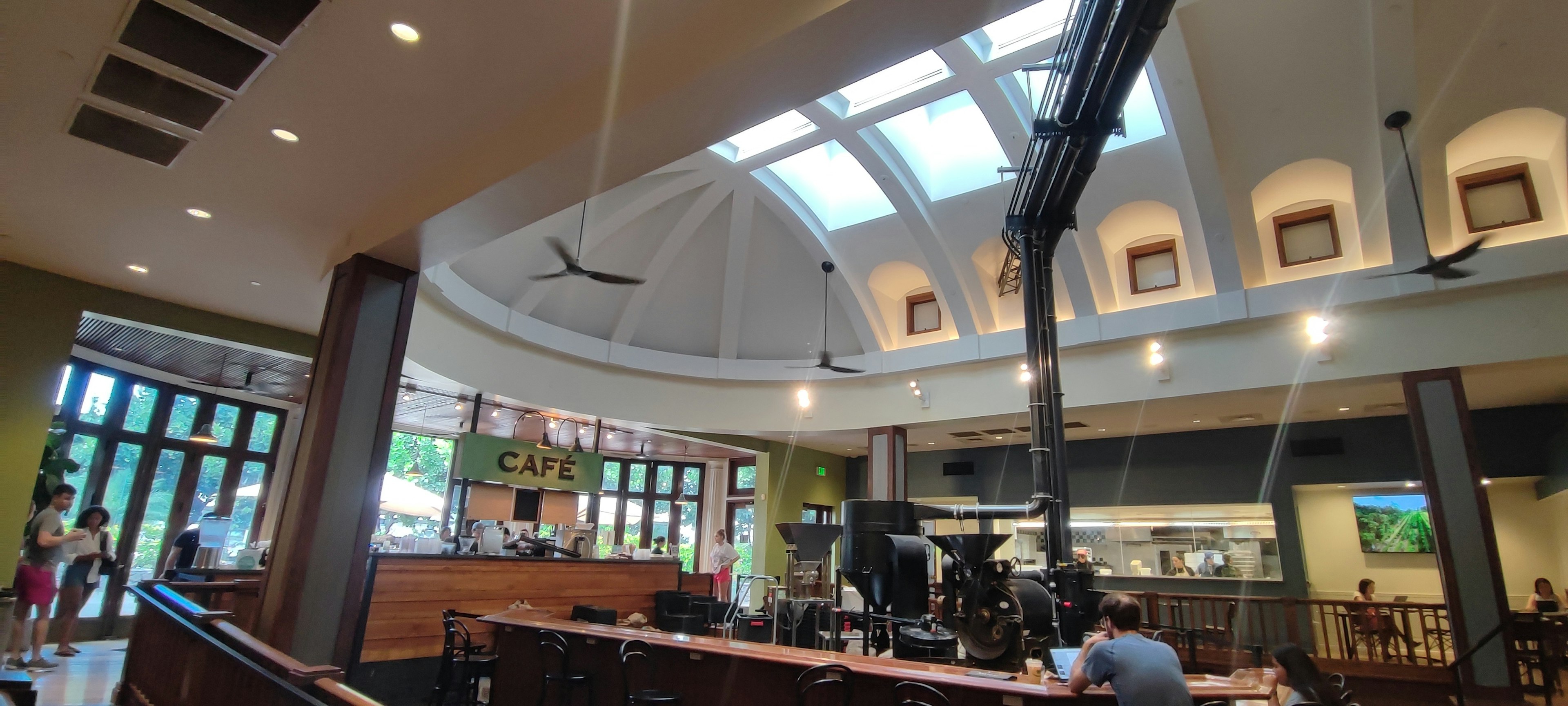 Interior de café moderno y espacioso con techo brillante y ventiladores