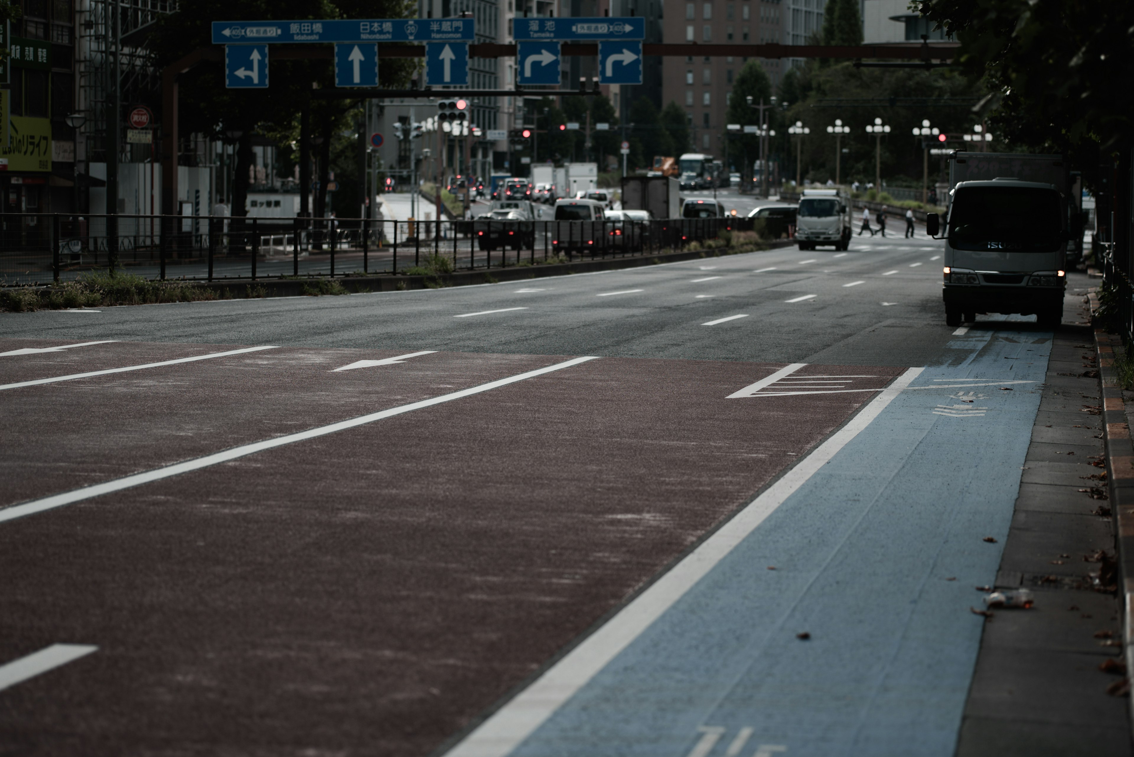 空いている道路と青い自転車道が見える都市の風景