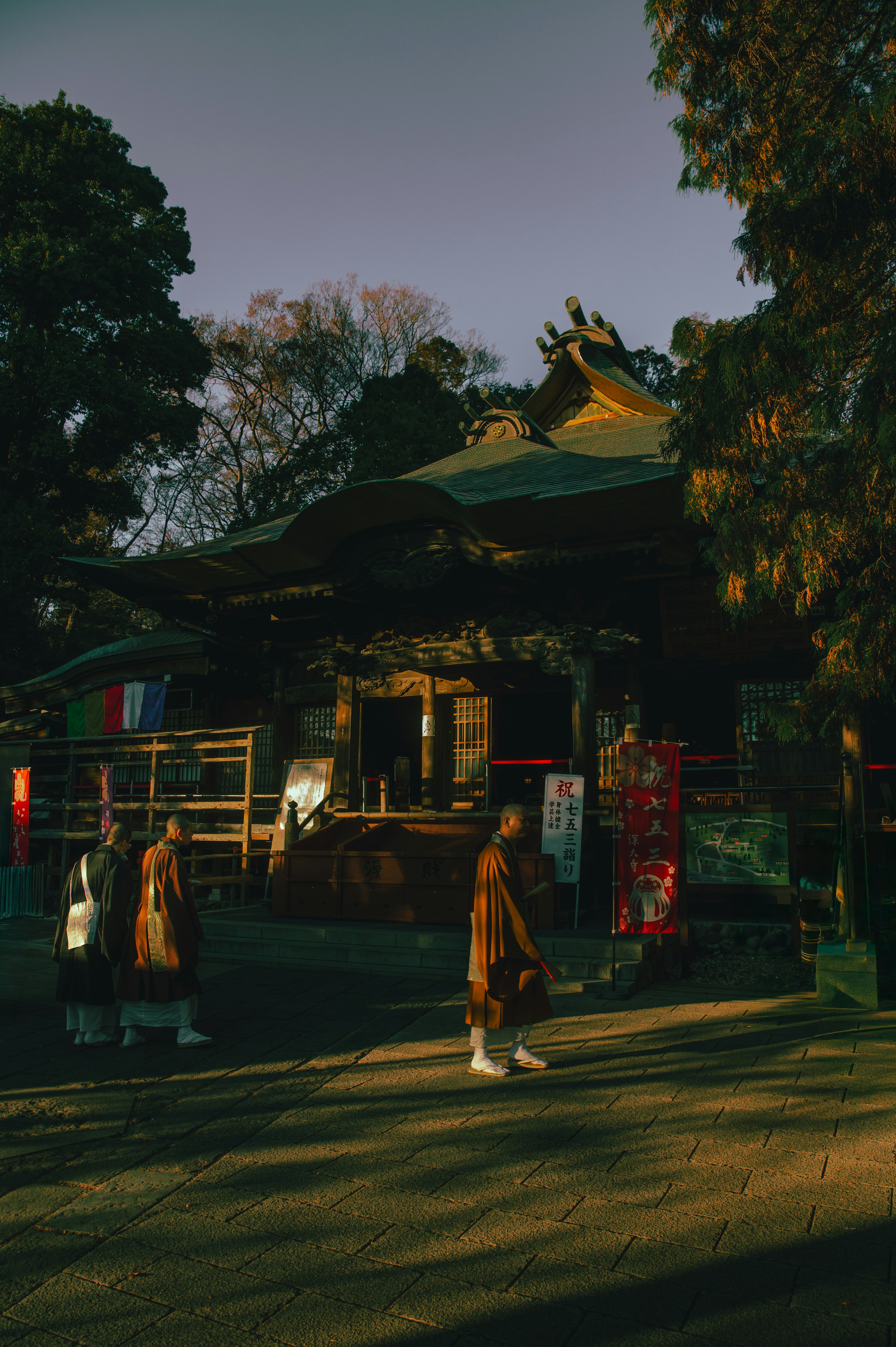 静かな寺院の周りを歩く人々の夕暮れのシーン