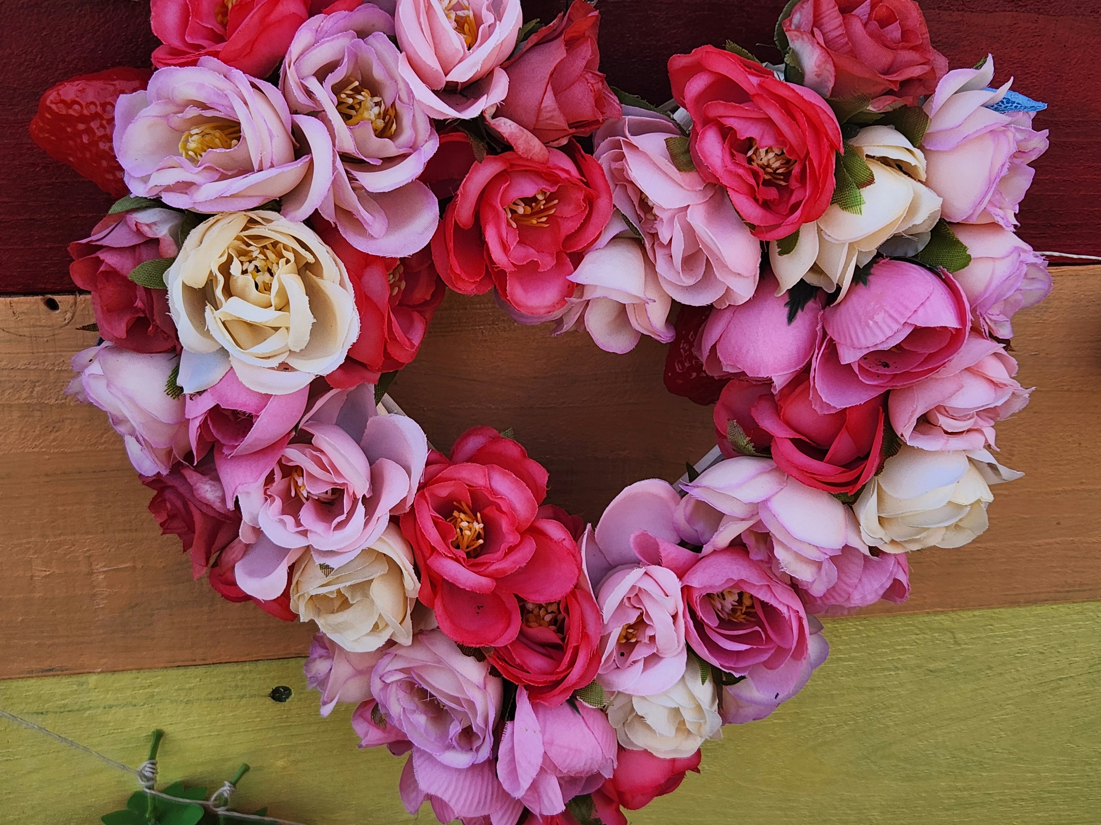 Heart-shaped floral wreath made of various colored roses