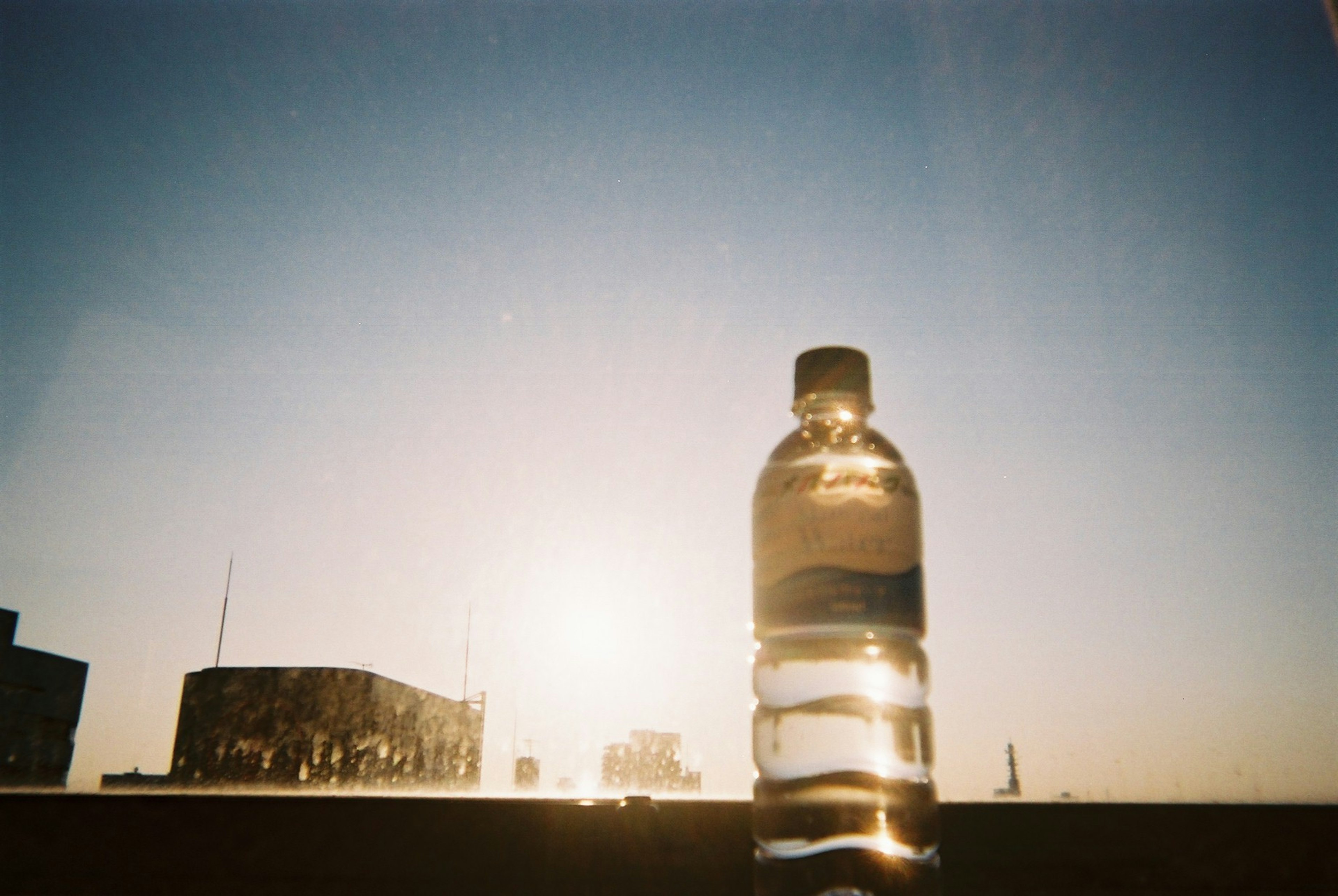 Silhouette of a water bottle against a sunset background