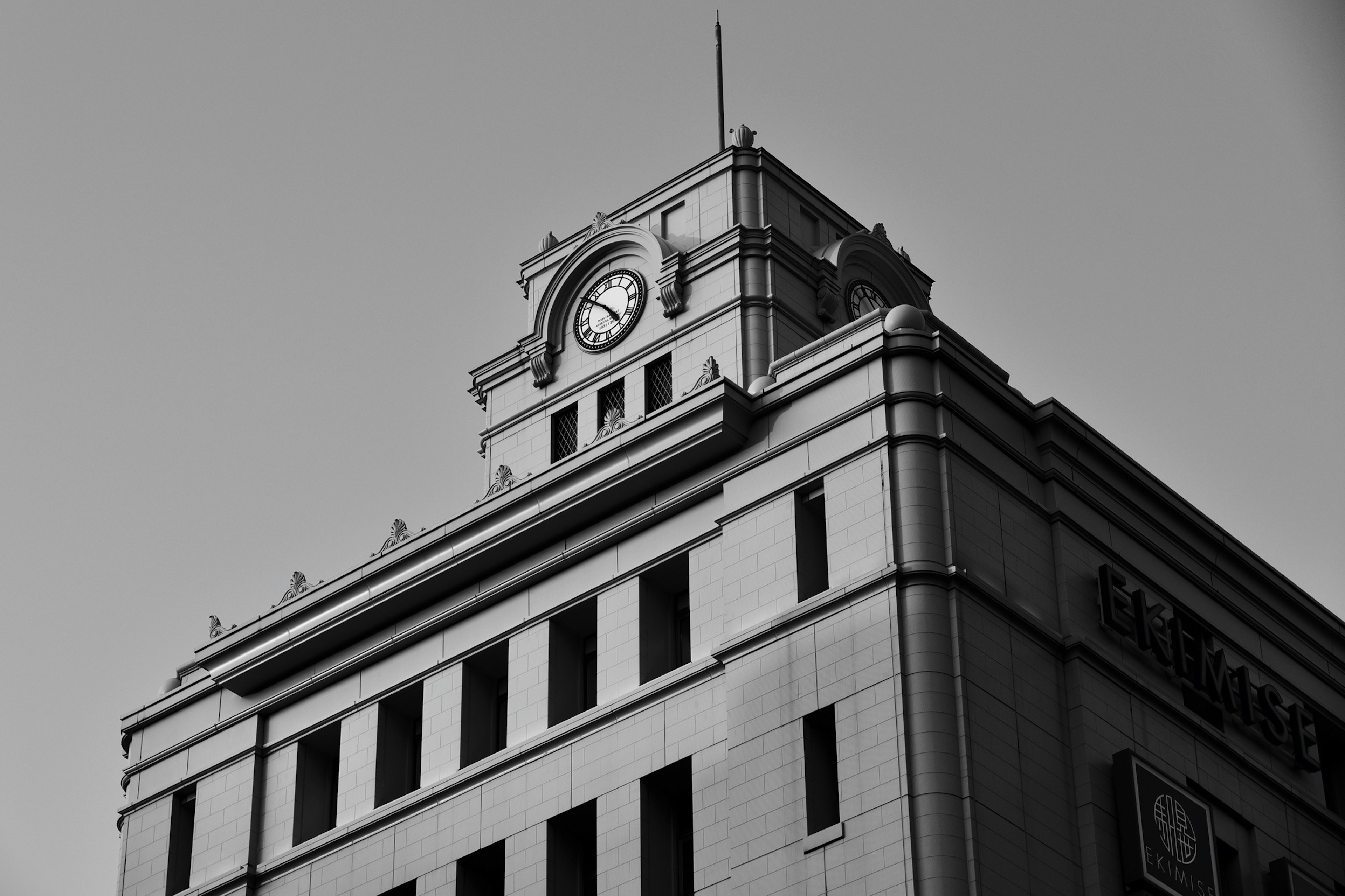 Primer plano de un edificio histórico con una torre del reloj en blanco y negro