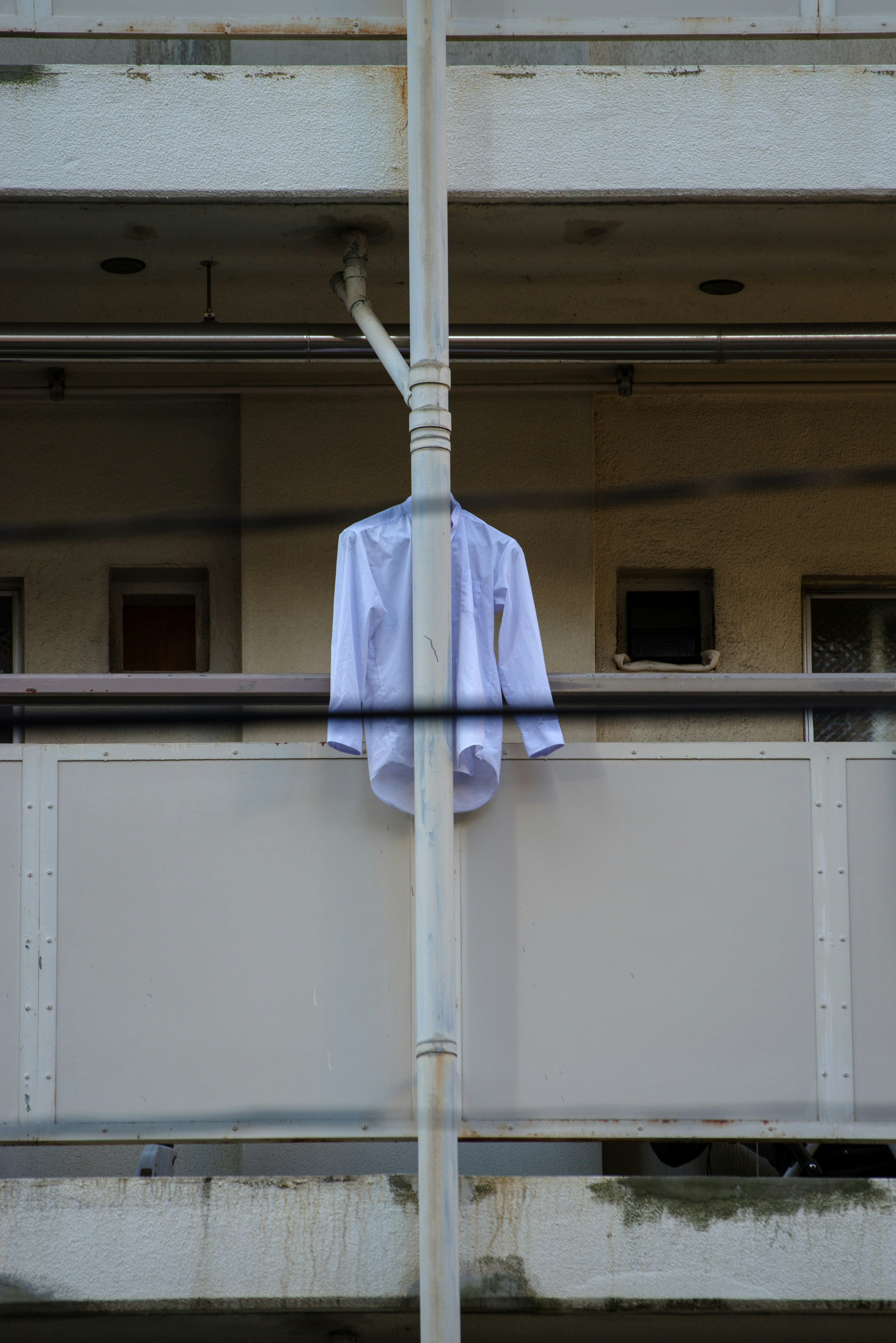 A white shirt hanging on a balcony railing