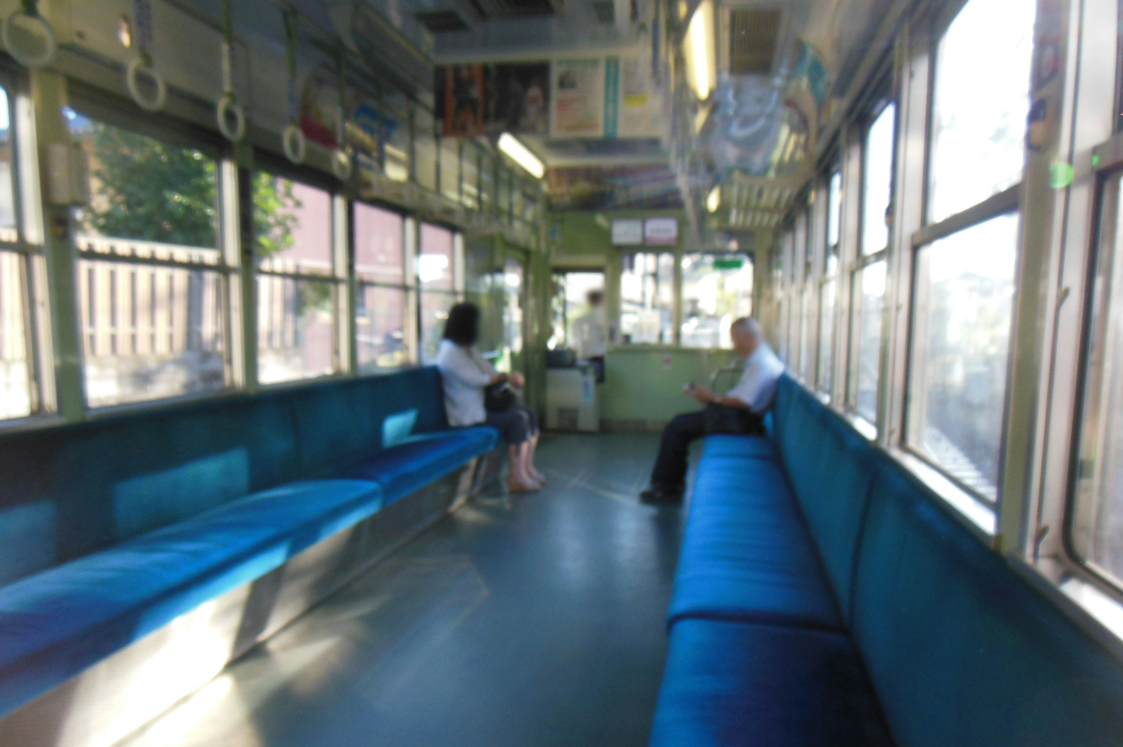 Interior of a nearly empty train carriage with blue seating