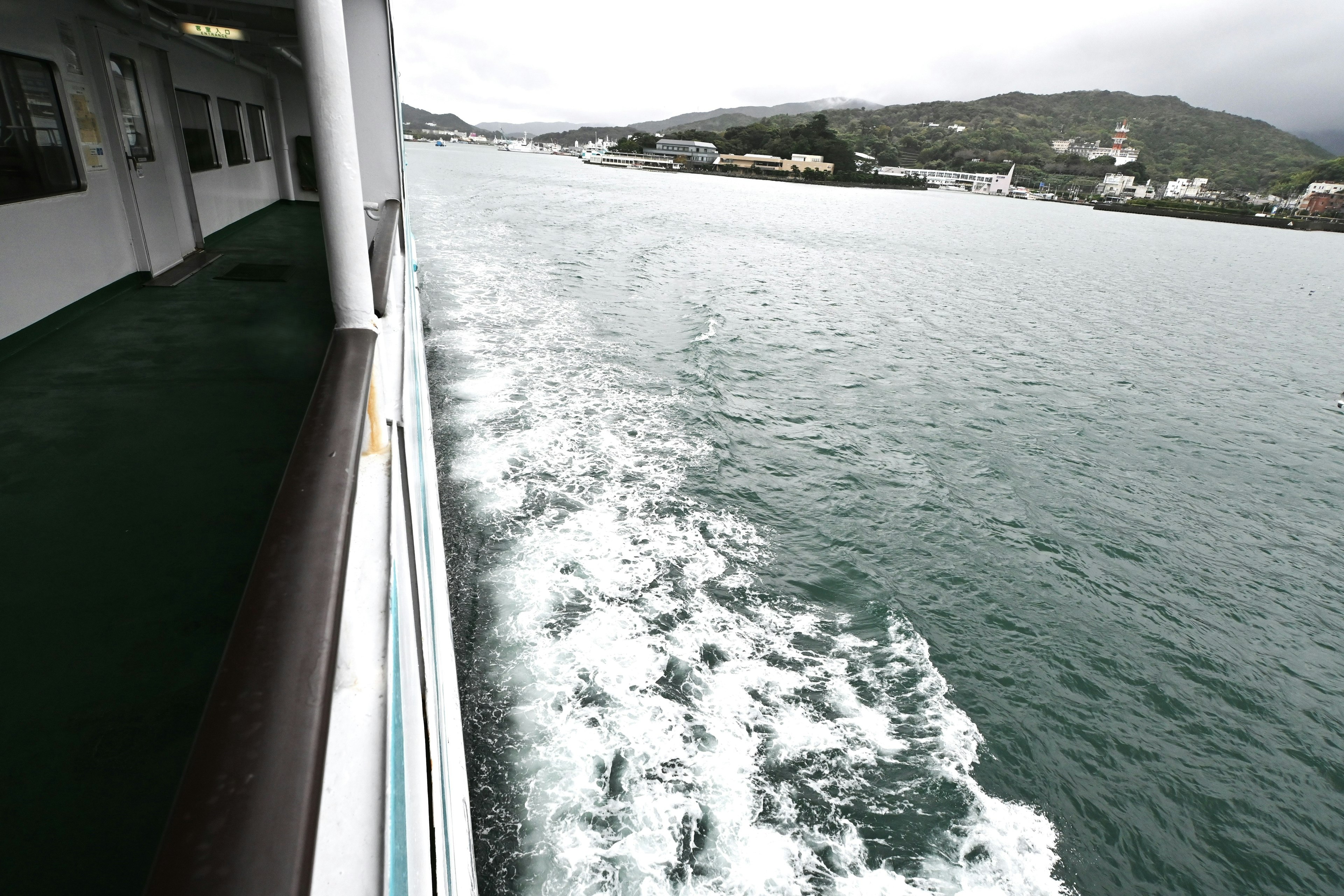 Vista del mar desde el lado de un barco con estela visible