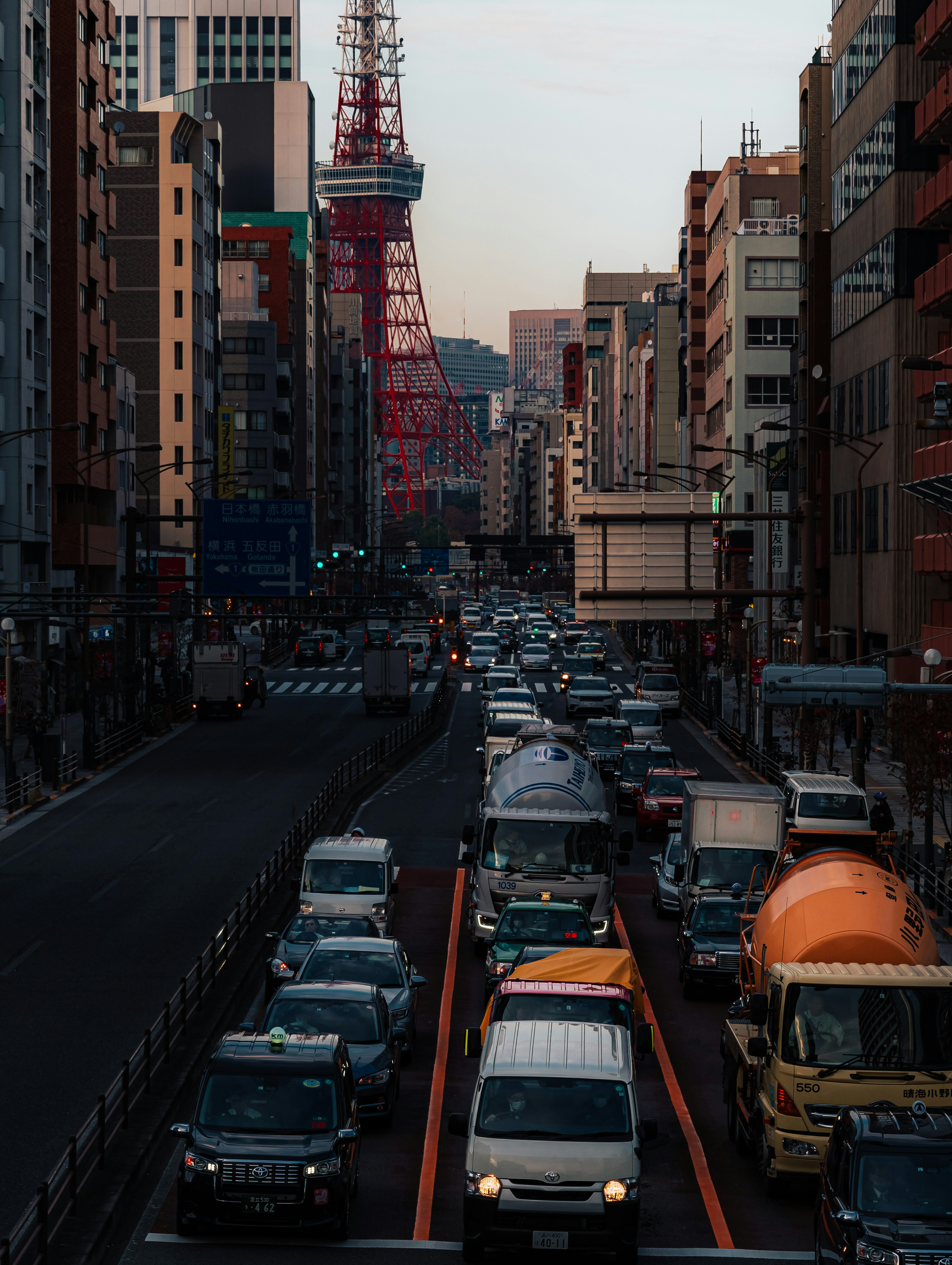 東京タワーが見える賑やかな都市の通りで車が渋滞している