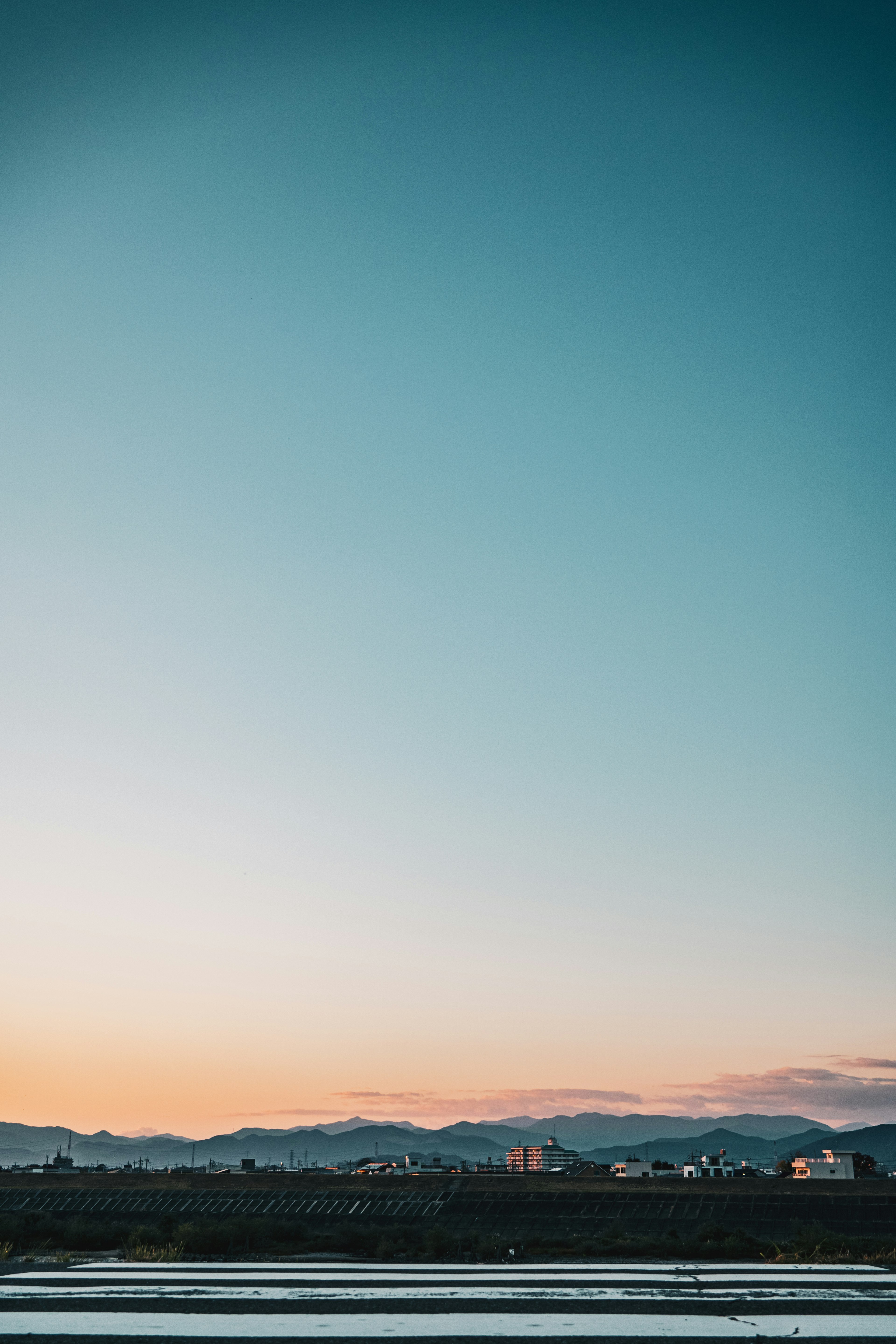 青い空とオレンジの夕焼けが広がる風景