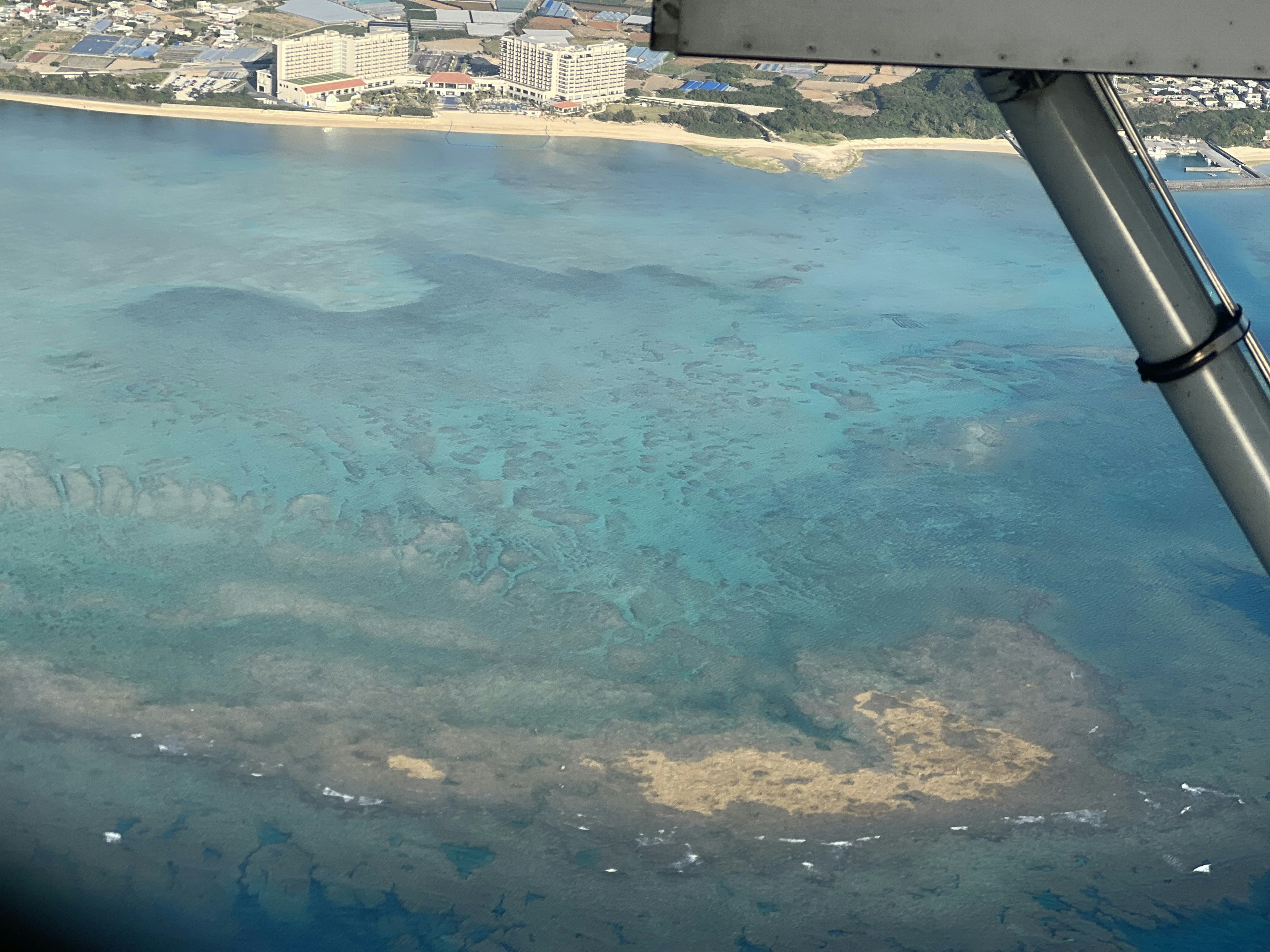 海の青い色とサンゴ礁の模様が見える空撮画像