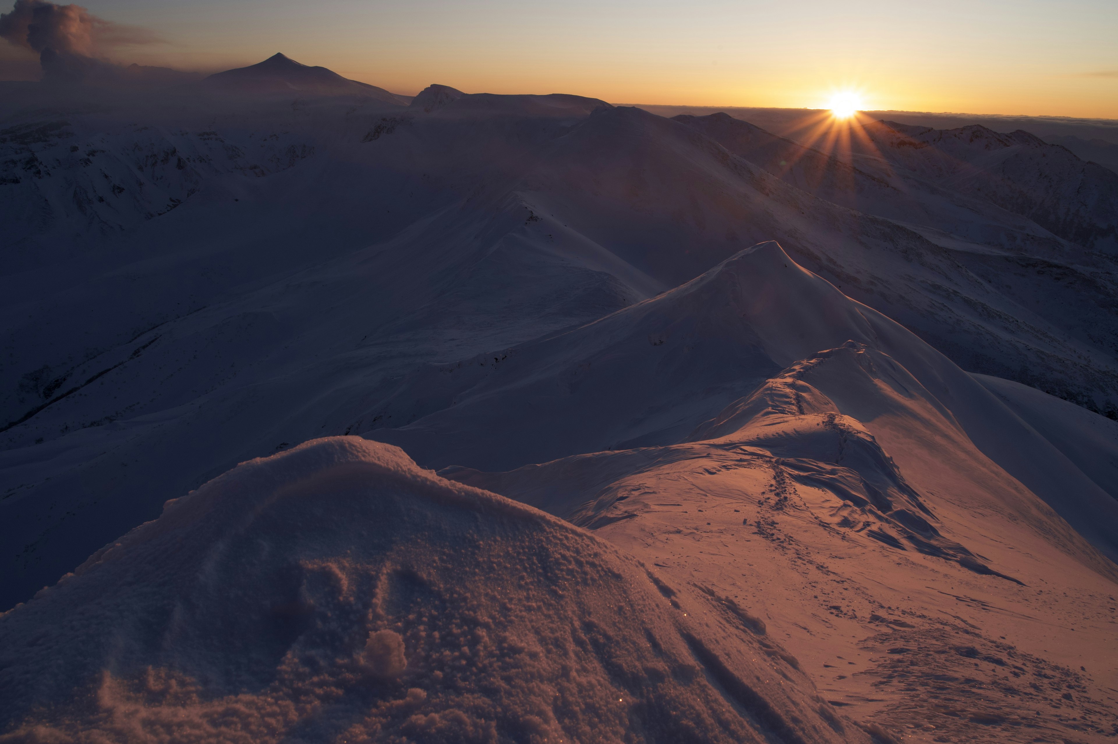 Verschneite Berge mit Sonnenuntergang