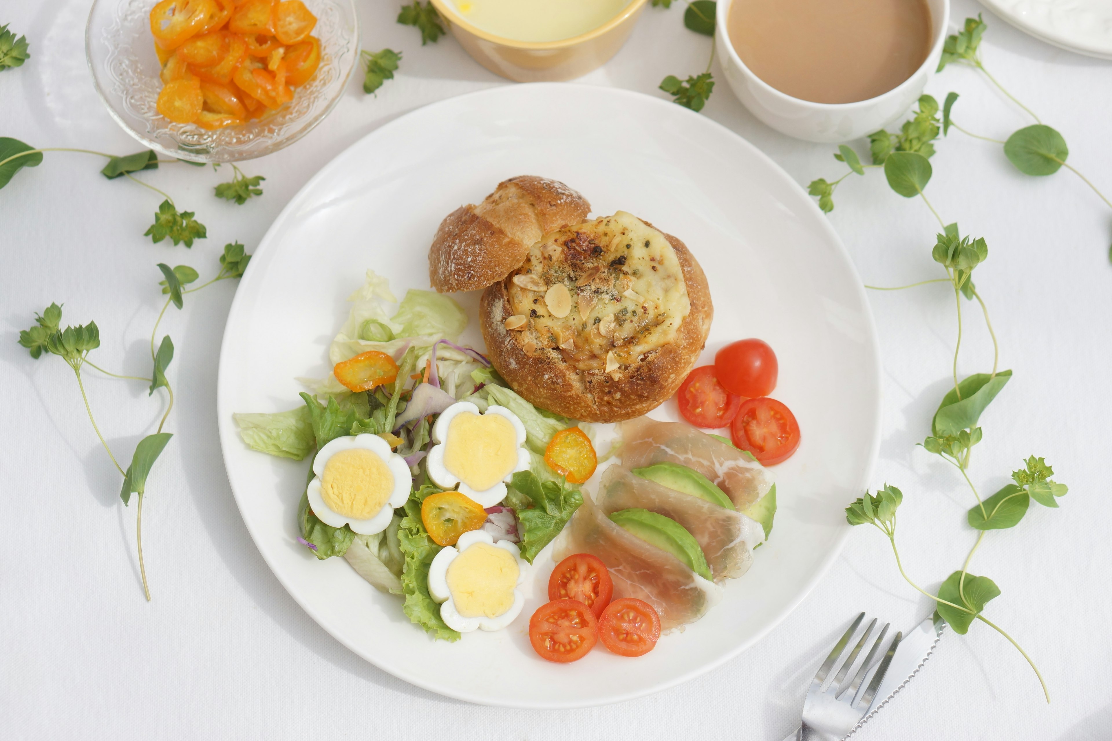 Bunt dekorierter Frühstücksteller mit Salat, Tomaten, Eiern und Brot