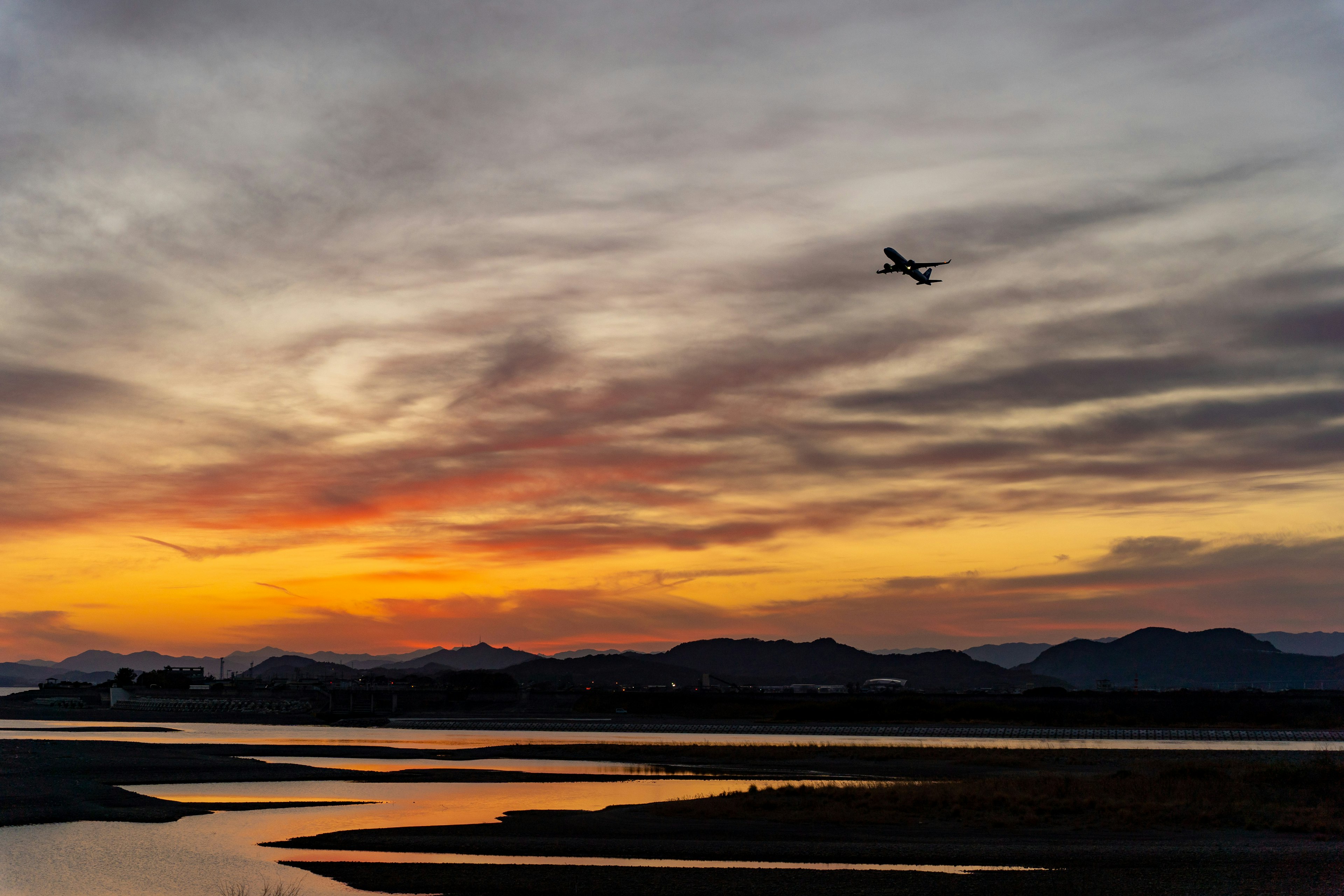 Un paysage magnifique avec un avion volant contre un ciel au coucher du soleil