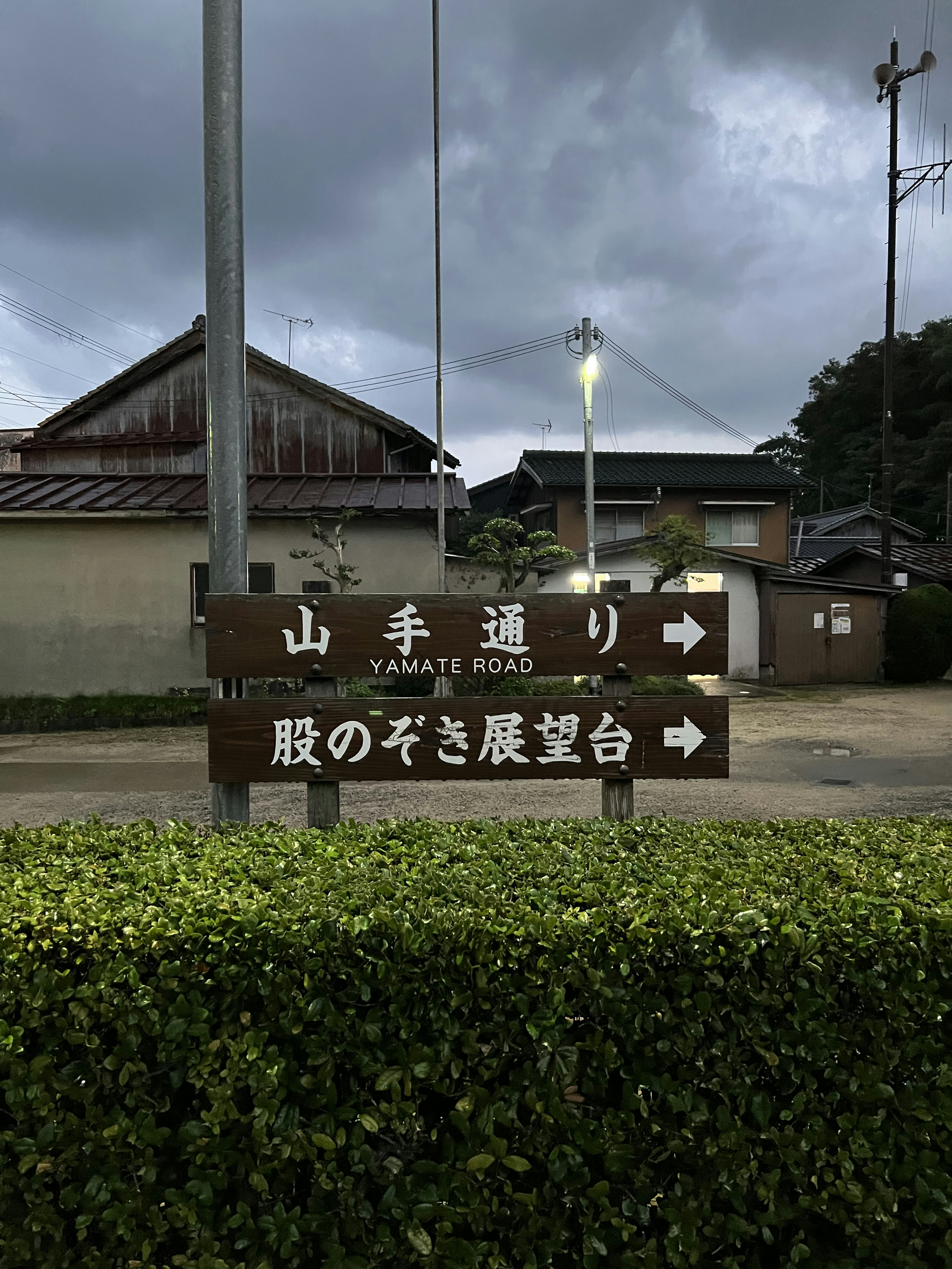 山手通りの標識がある風景、曇り空、周囲の住宅が見える