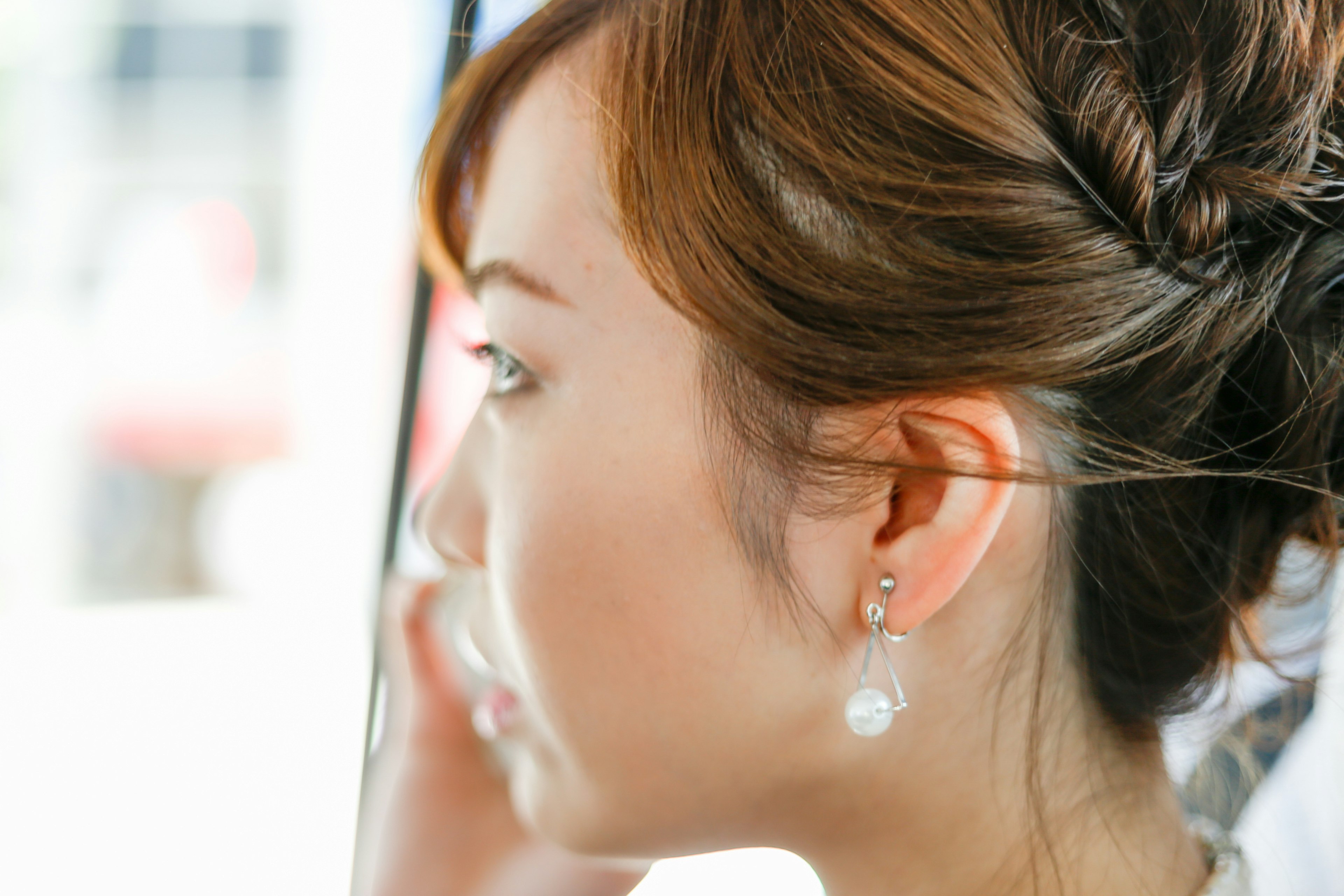 Profil seorang wanita dengan anting-anting menampilkan gaya rambut dan ekspresi yang indah