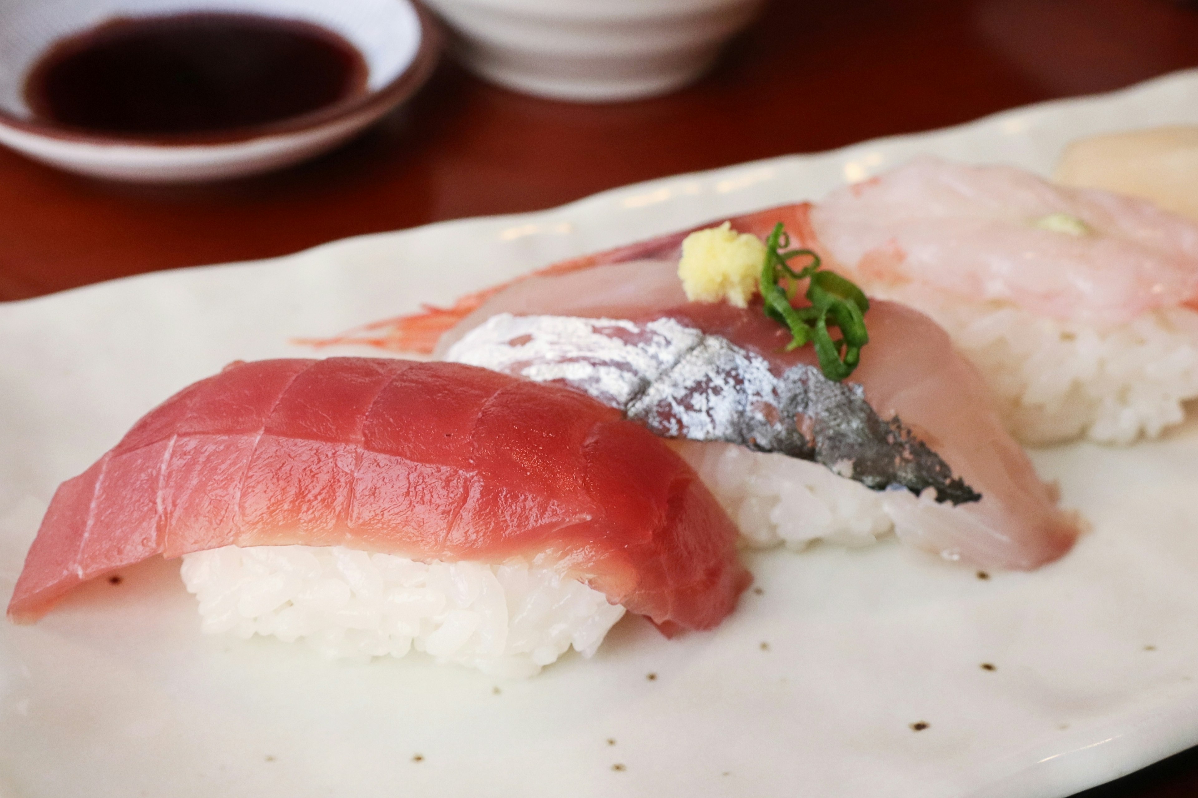 Gambar sushi segar yang disajikan dengan nigiri tuna dan makarel