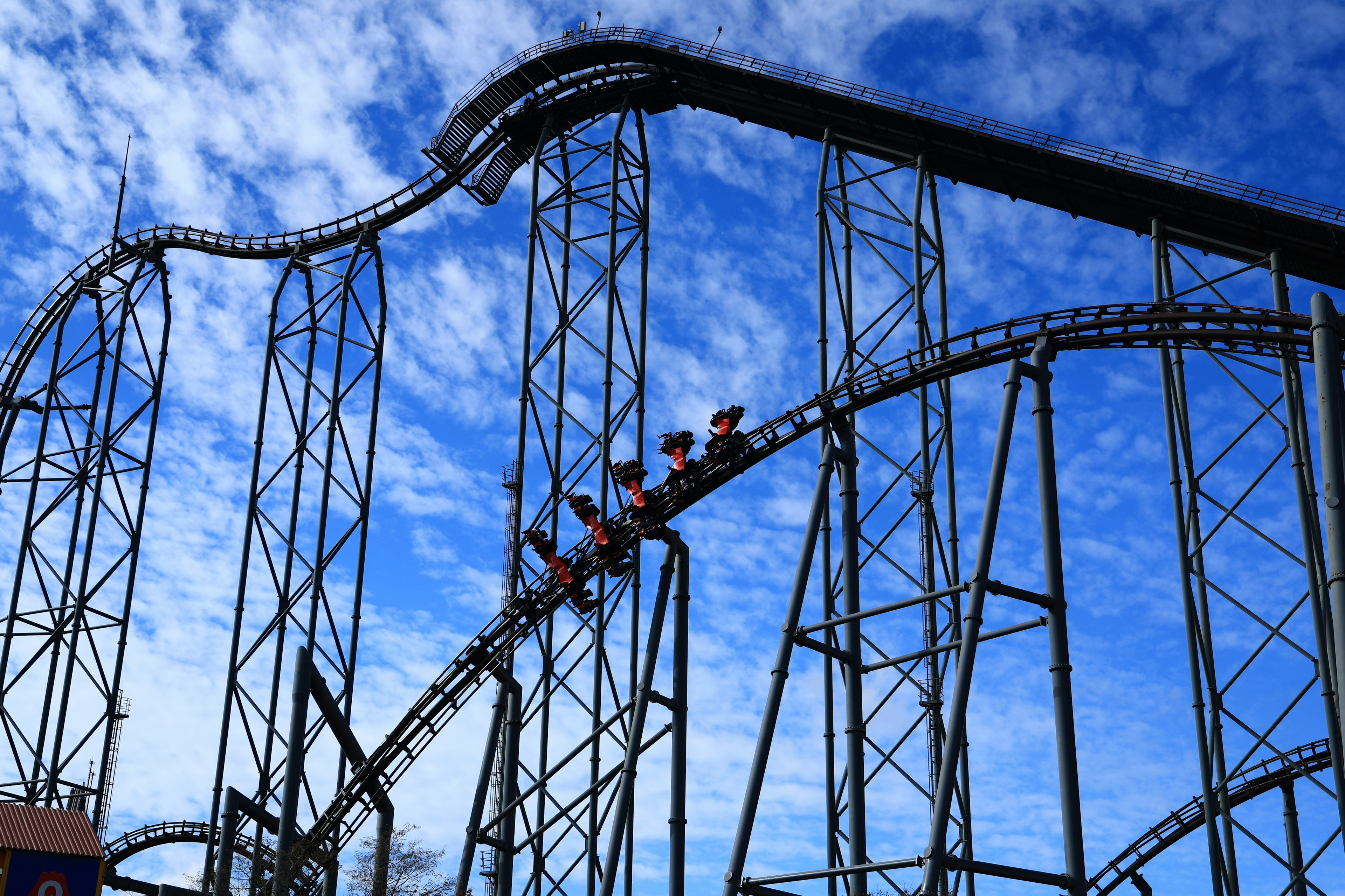 Roller coaster ascending against a backdrop of blue sky