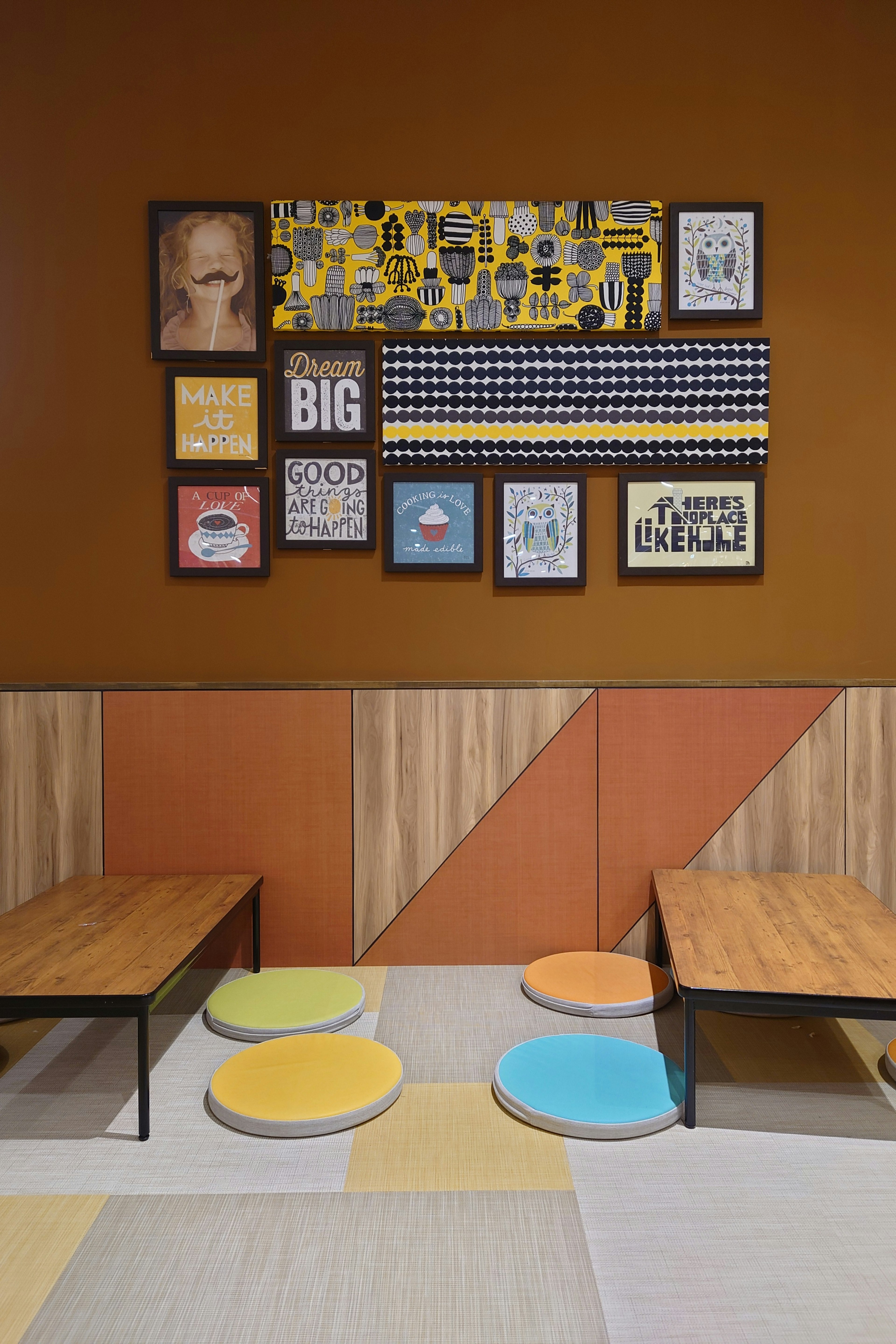 Casual seating area with colorful cushions and an art wall featuring various frames