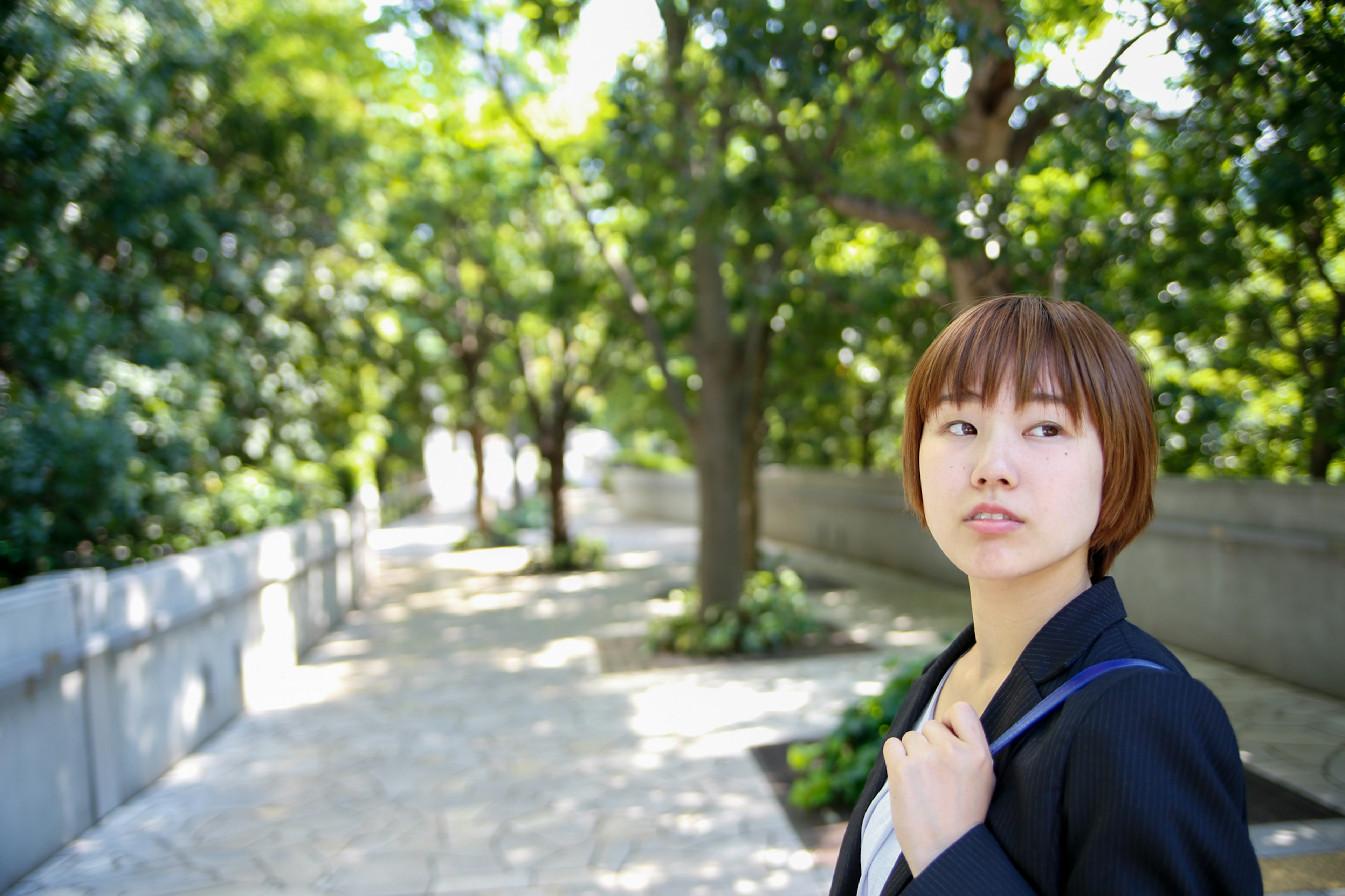 A woman walking along a path surrounded by greenery