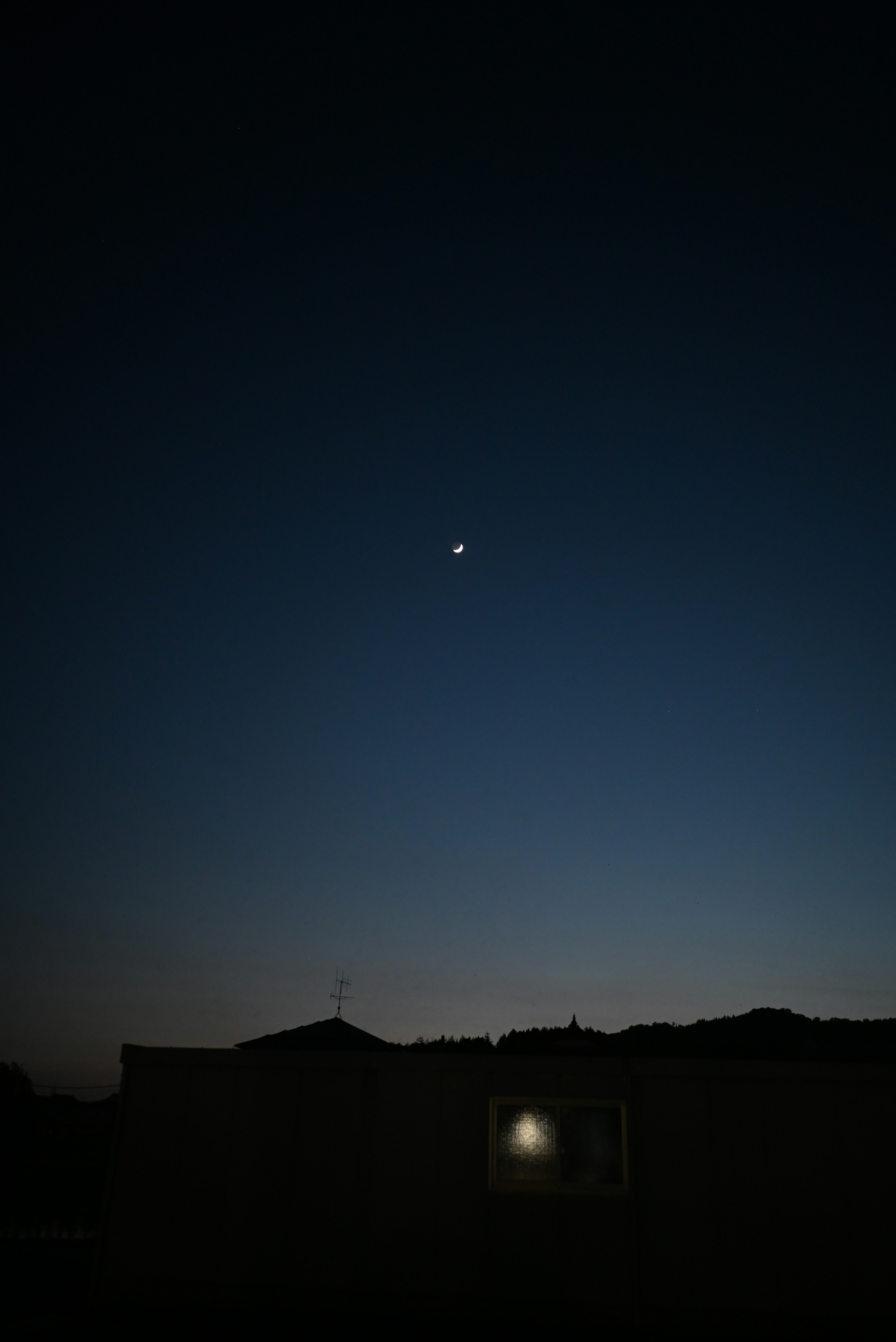 Bulan sabit dan bintang di langit malam dengan siluet bangunan