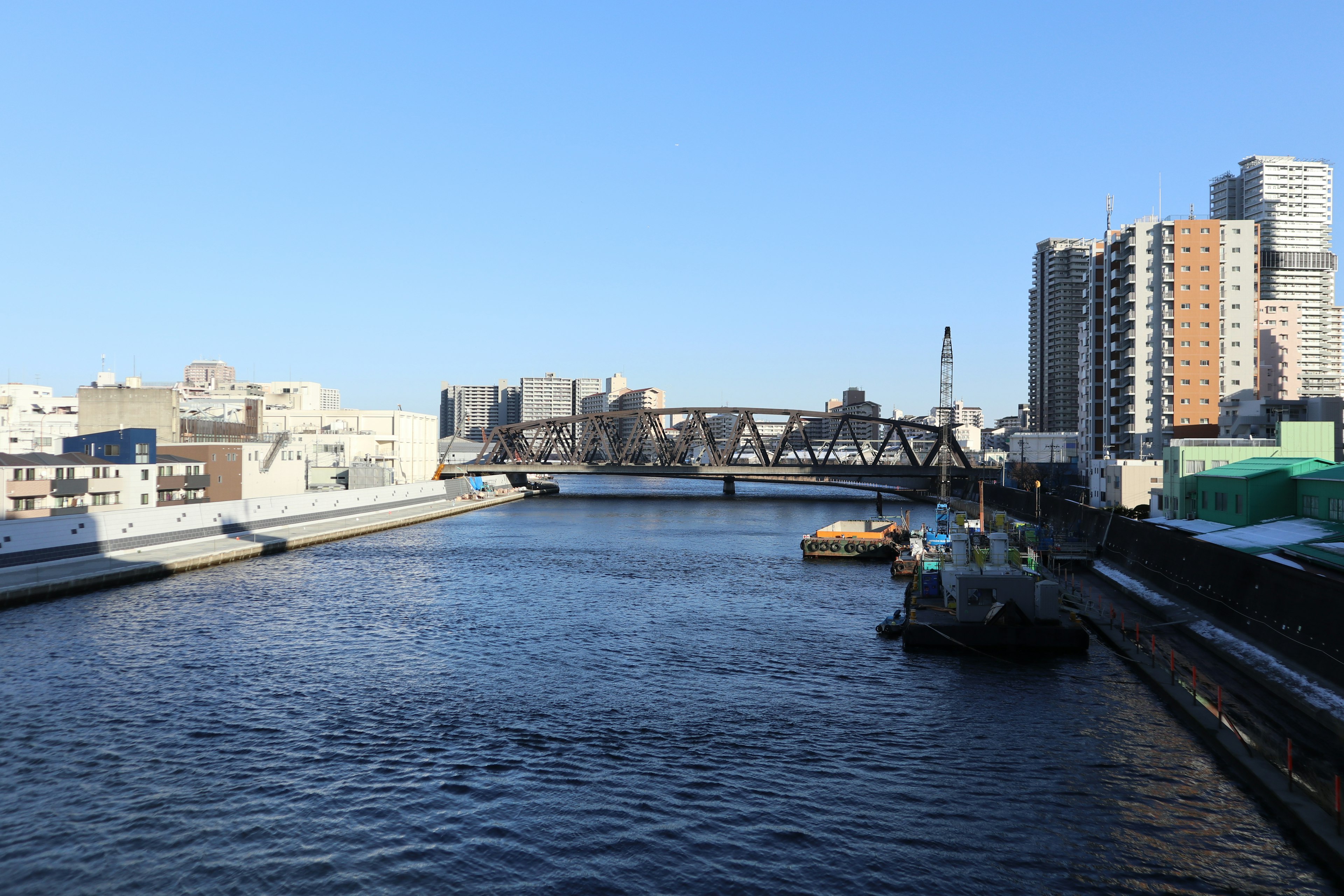 Fiume che scorre sotto un cielo blu chiaro con edifici moderni lungo le rive