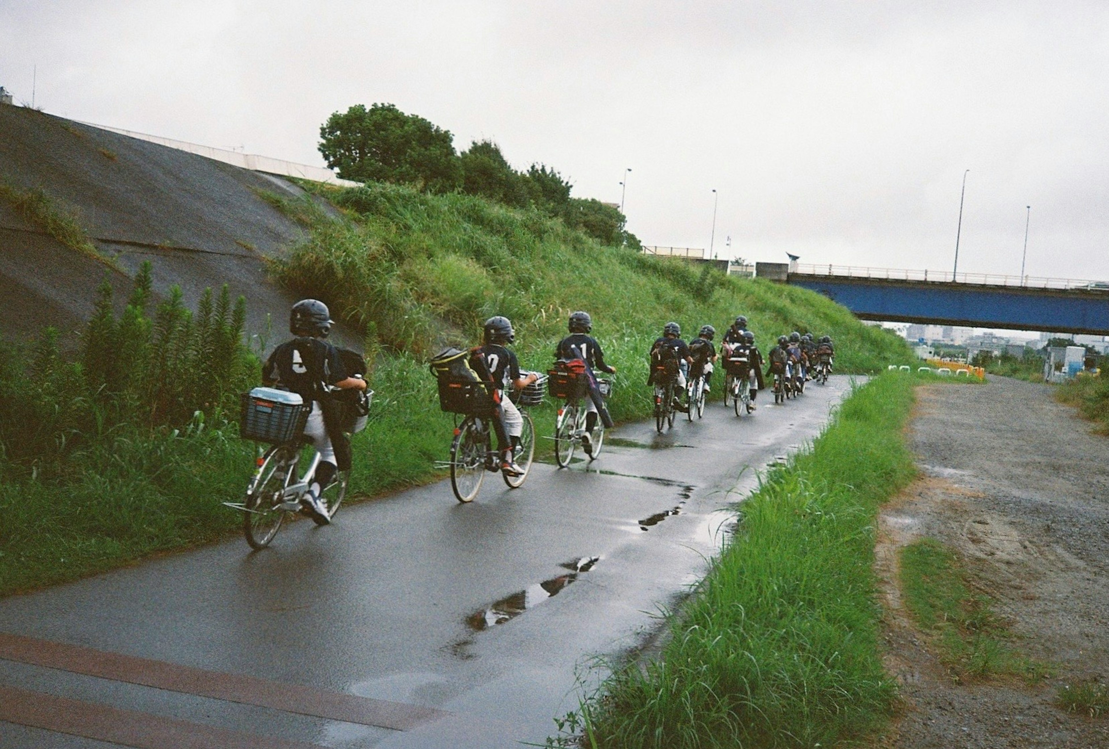 Fila de ciclistas de entrega montando en la lluvia