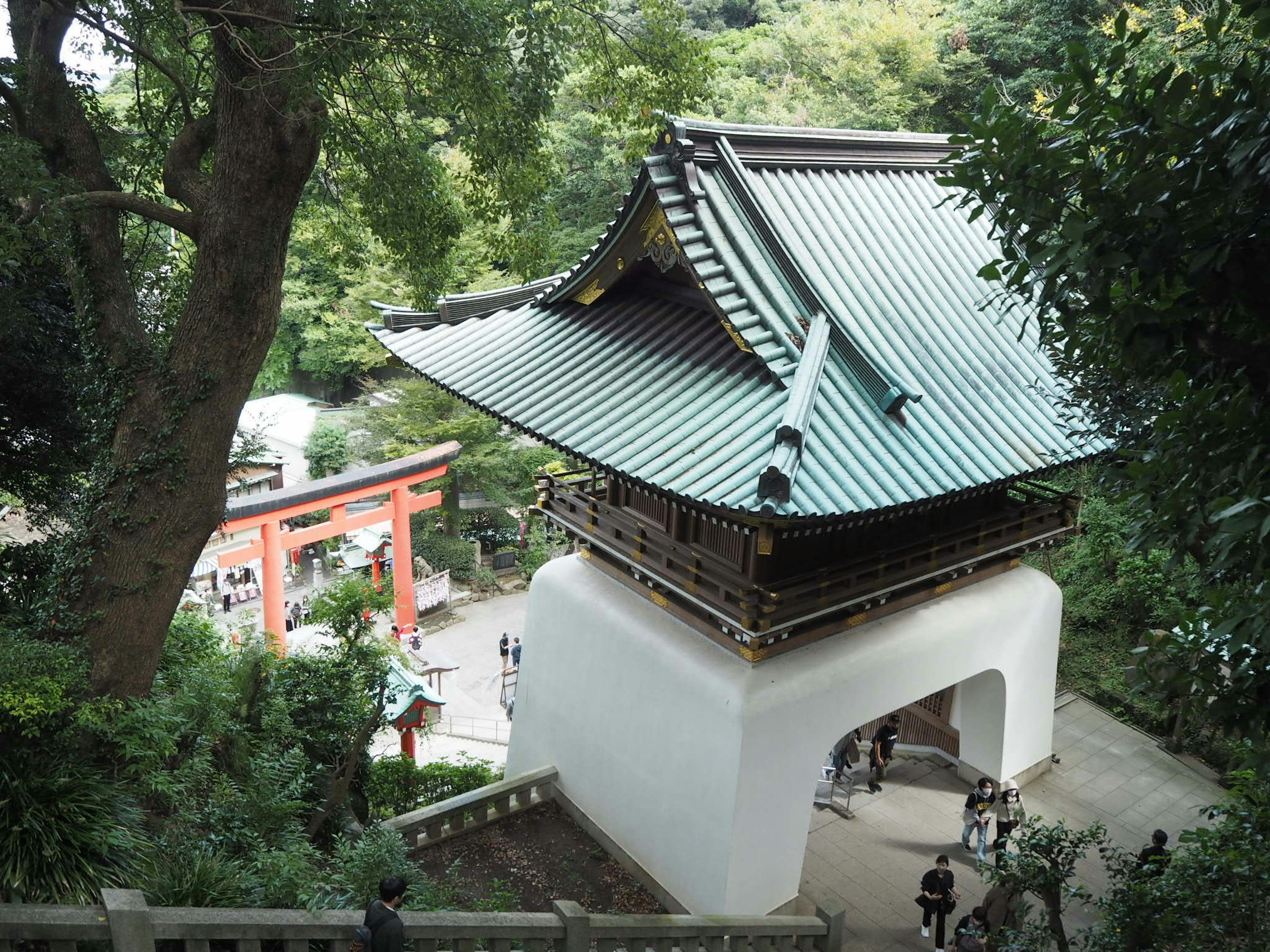 Traditional Japanese temple roof surrounded by lush greenery