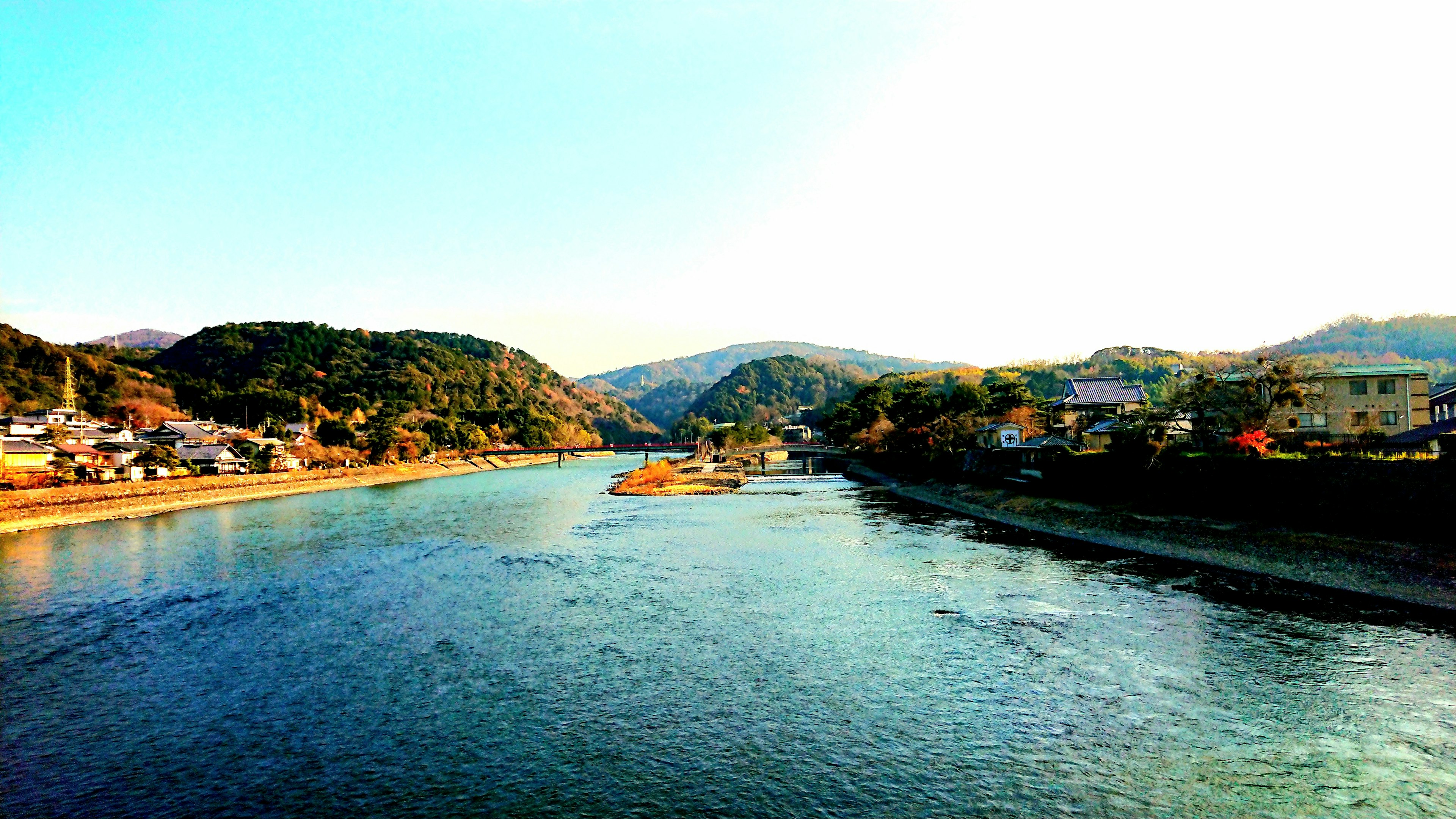 Vista panoramica di un fiume tranquillo circondato da colline e case