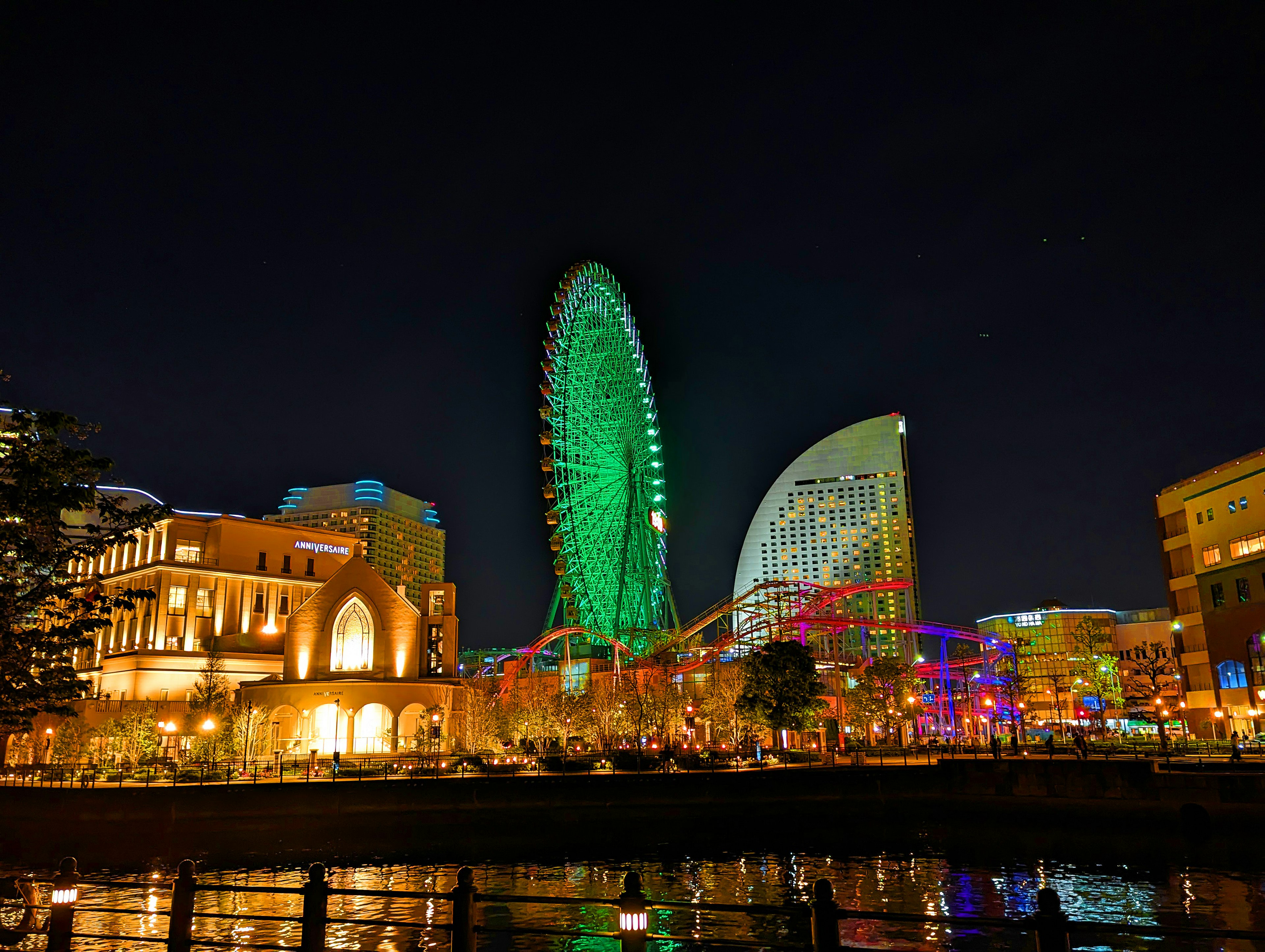 Grande roue illuminée et bâtiments colorés à Yokohama la nuit