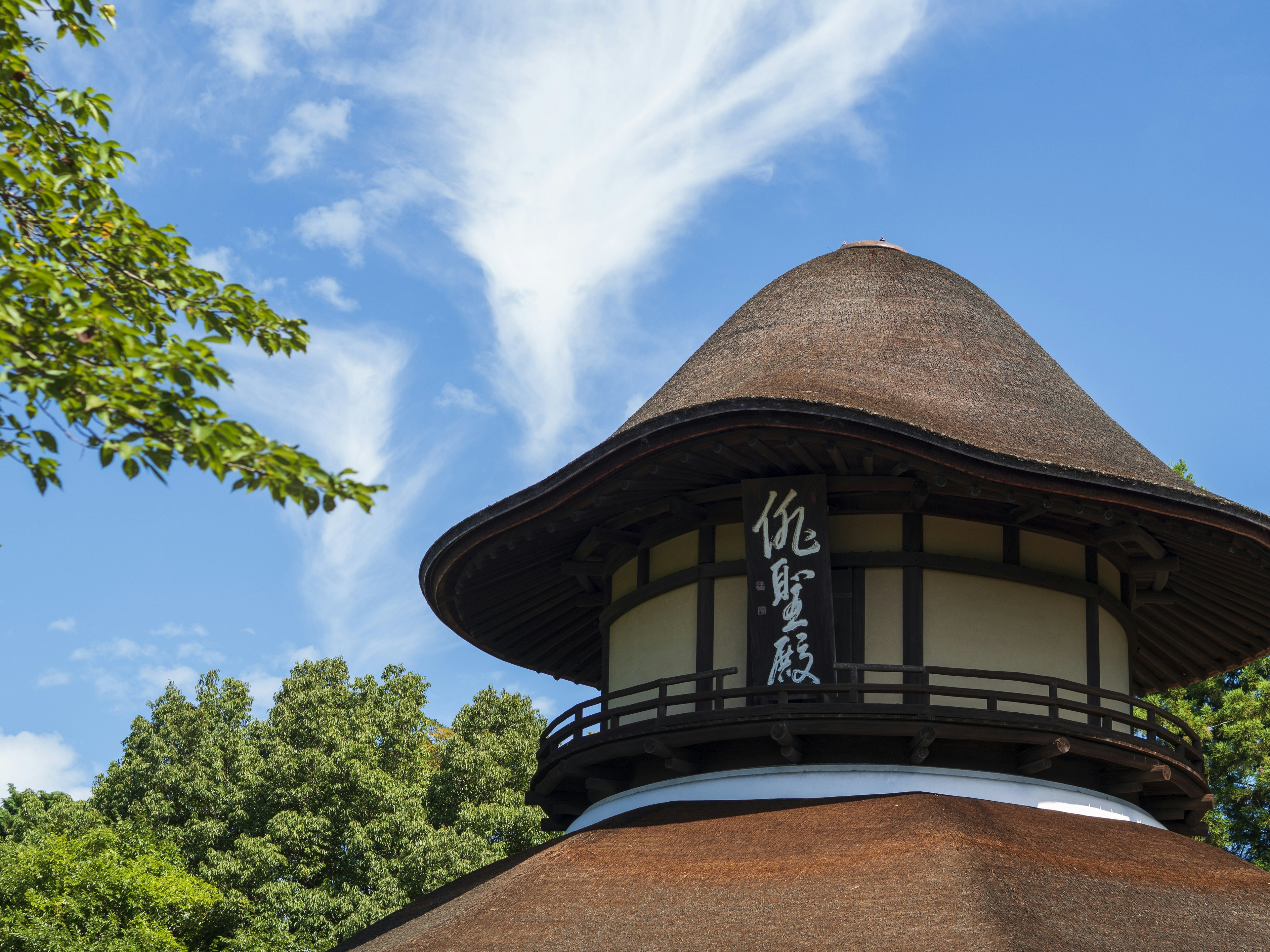 Dach eines traditionellen japanischen Gebäudes mit Schild unter blauem Himmel