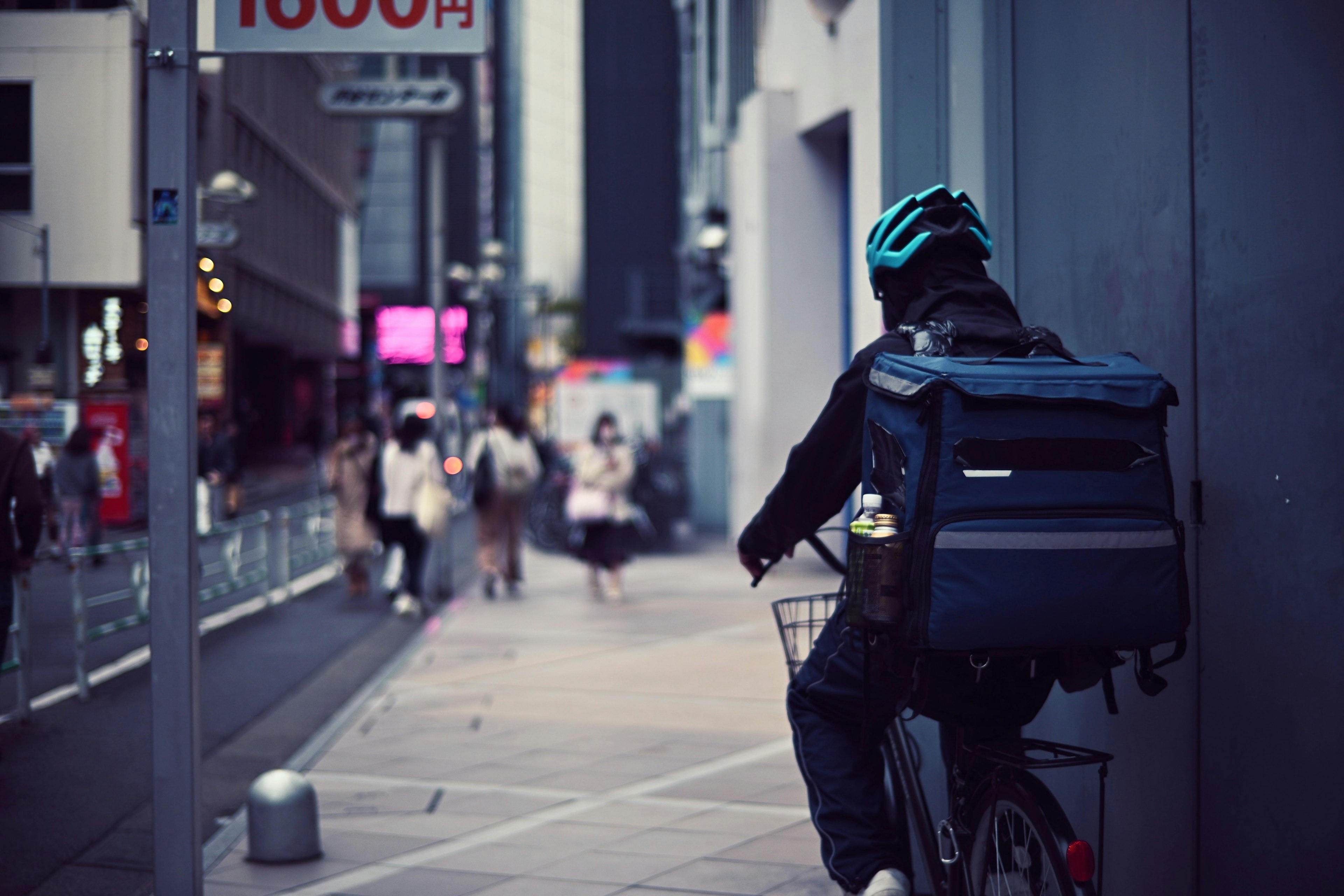 Corriere in bicicletta che attraversa una strada della città