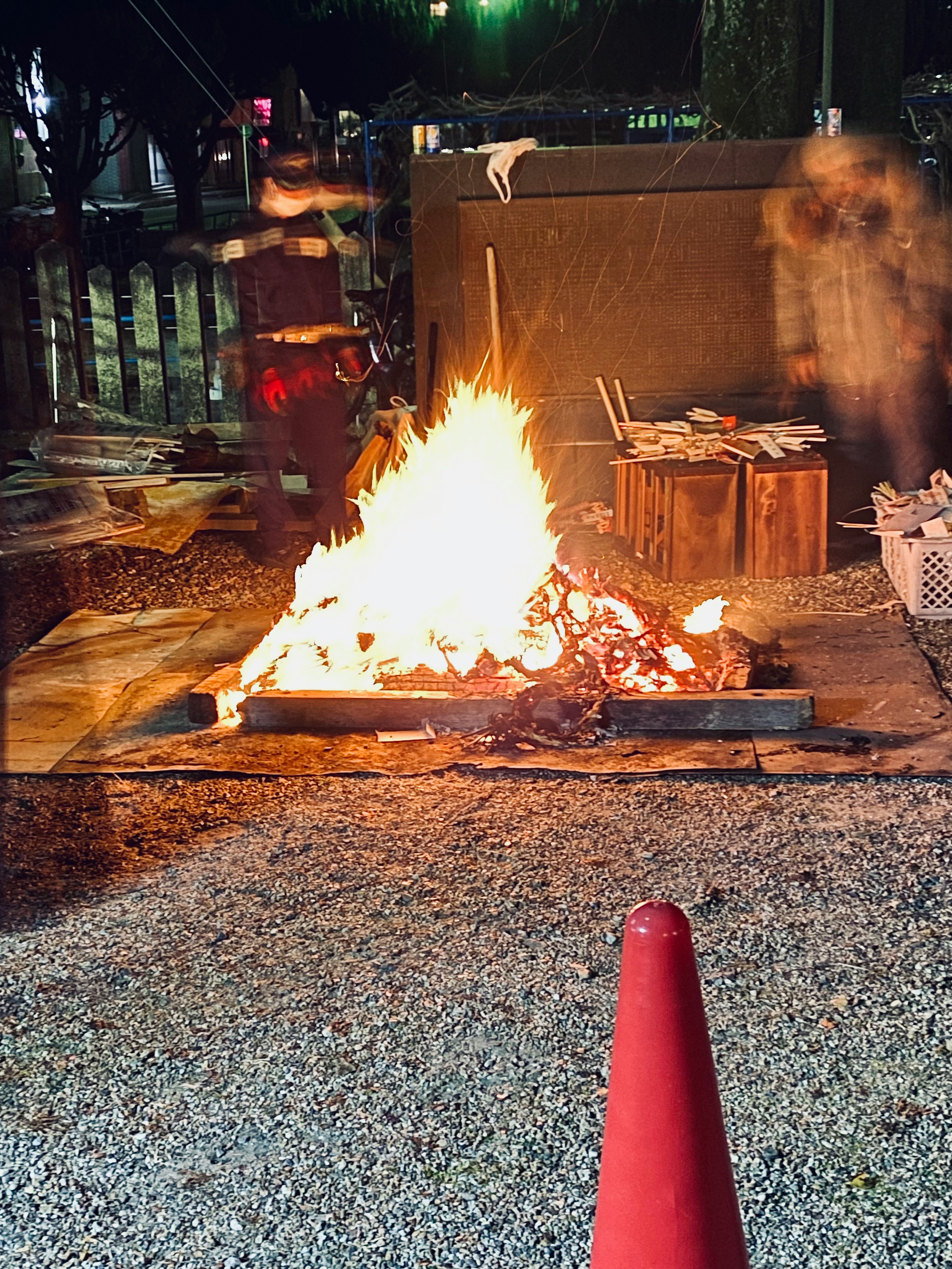 Un feu brûlant la nuit avec des matériaux en bois environnants