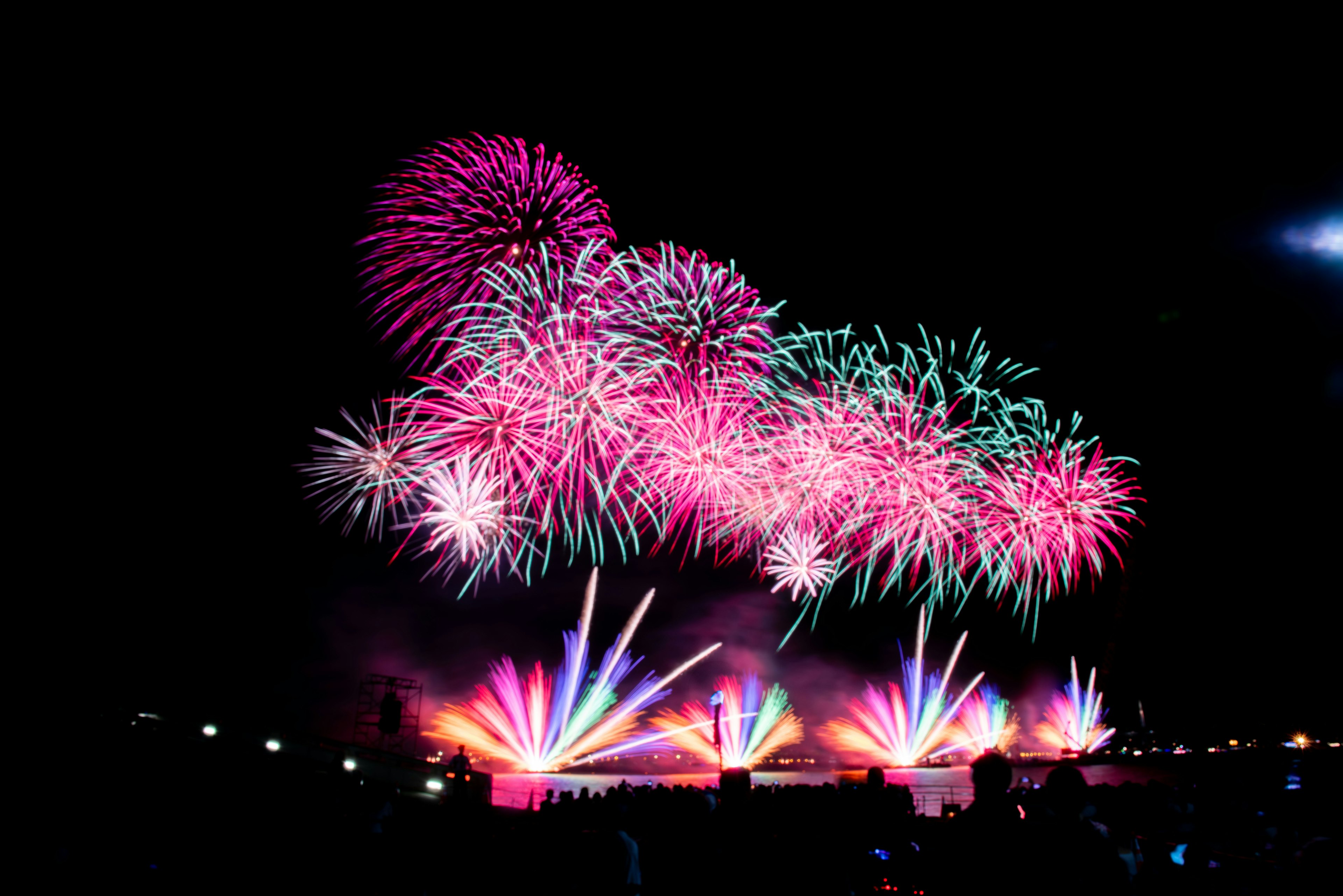 夜空に広がる色とりどりの花火と光の噴水