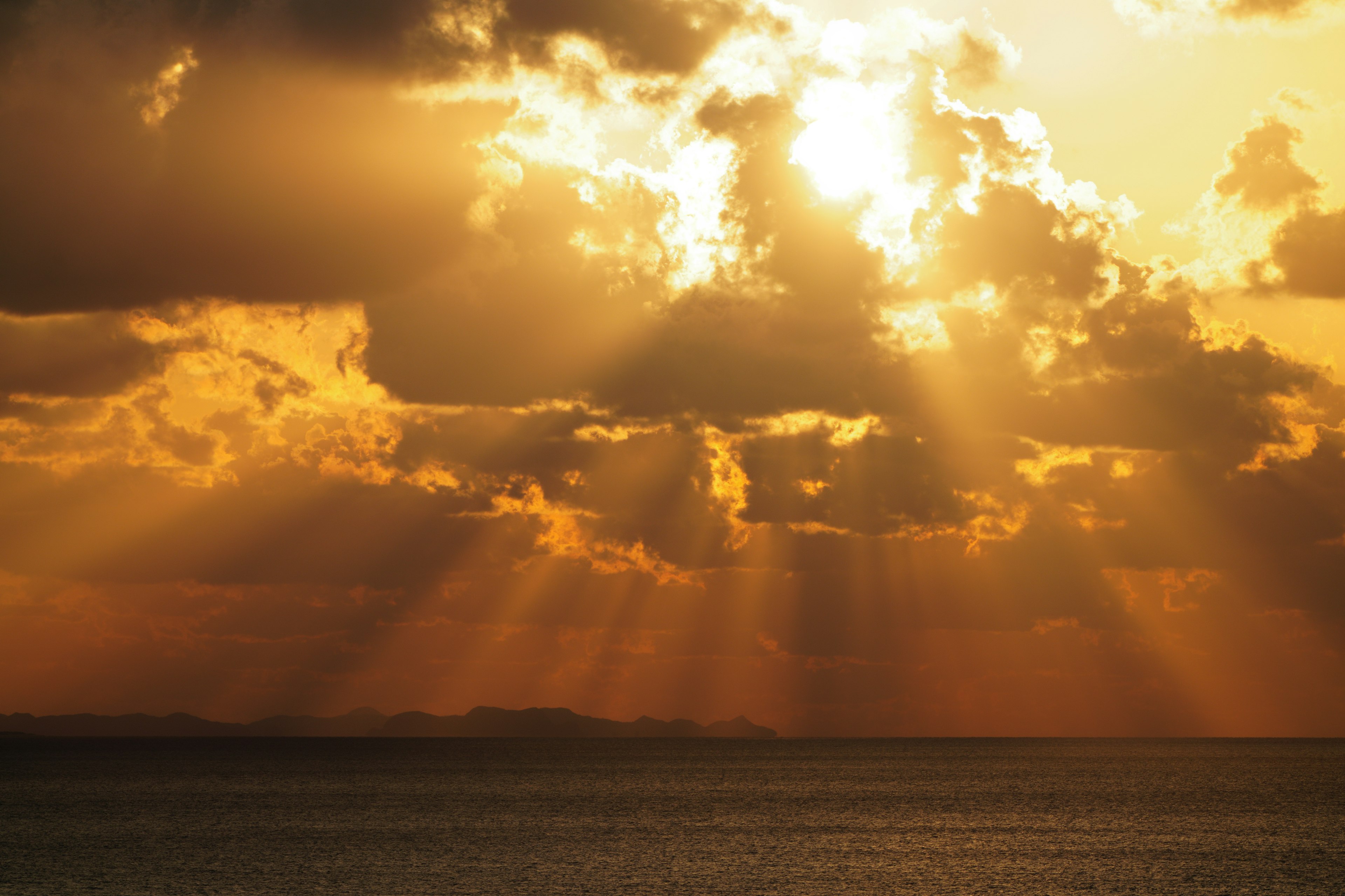 夕日の下で輝く雲と海の風景