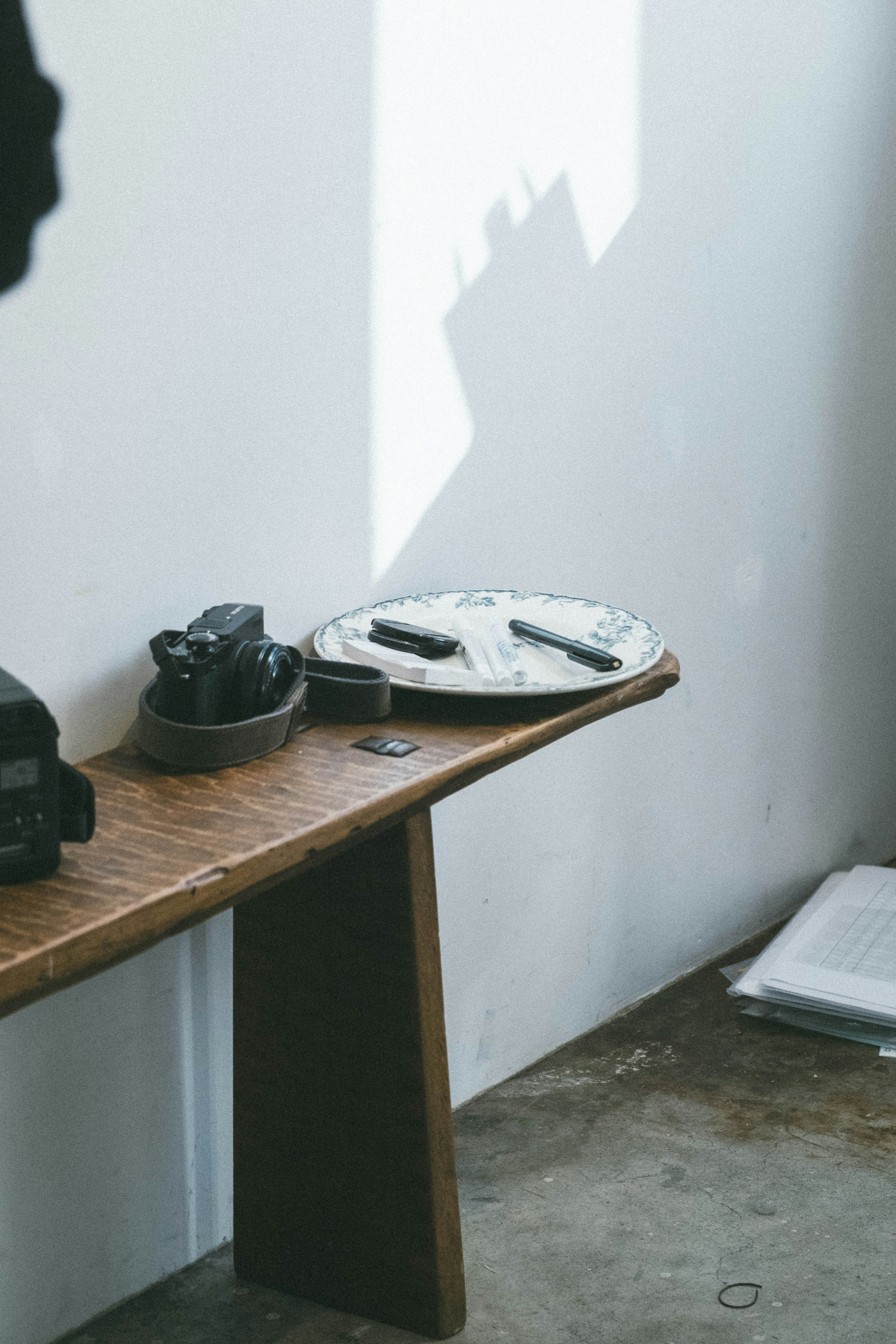 Simple interior featuring a wooden table with cameras and a white circular object