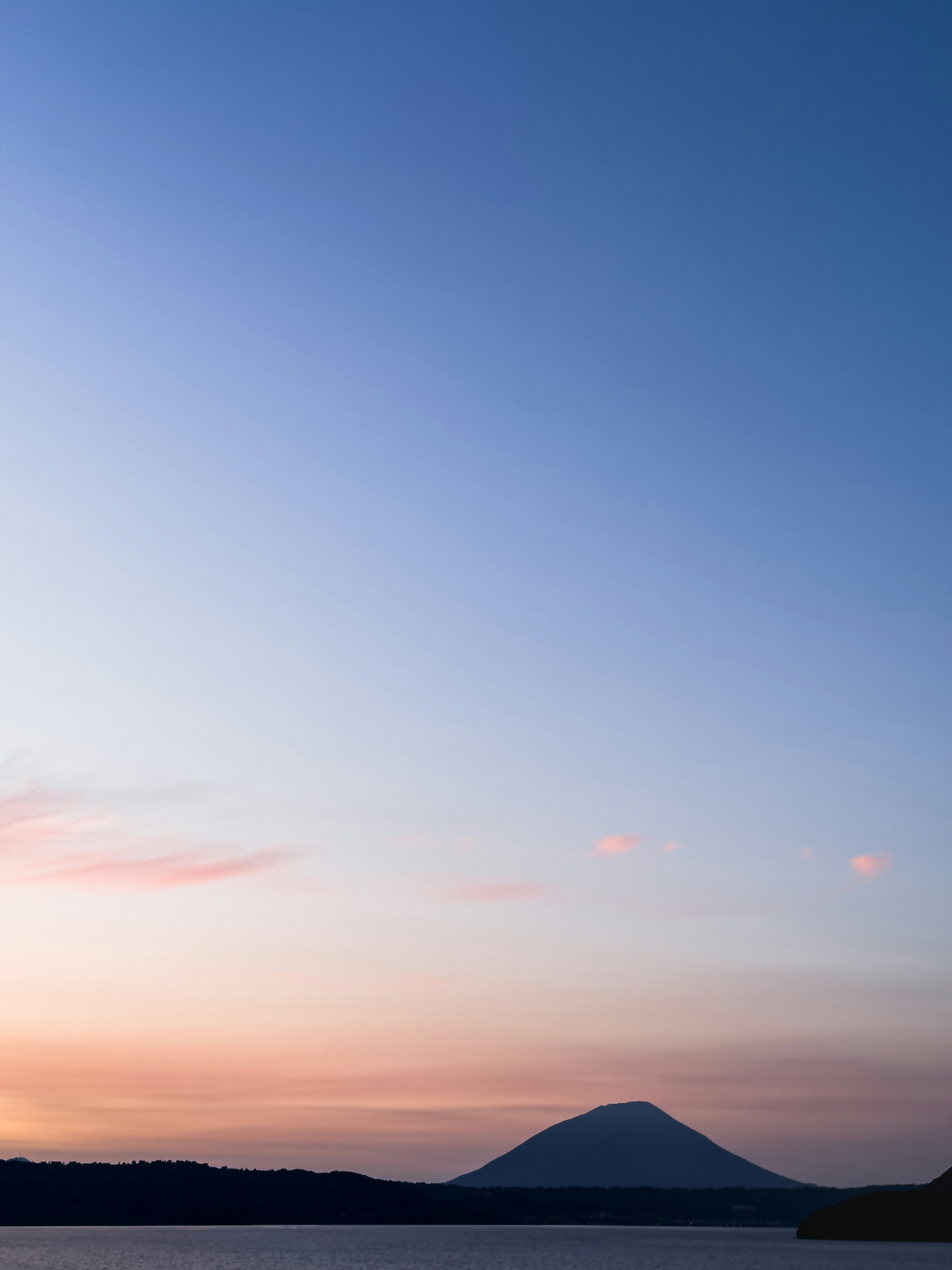 Cielo di tramonto calmo con silhouette di montagna