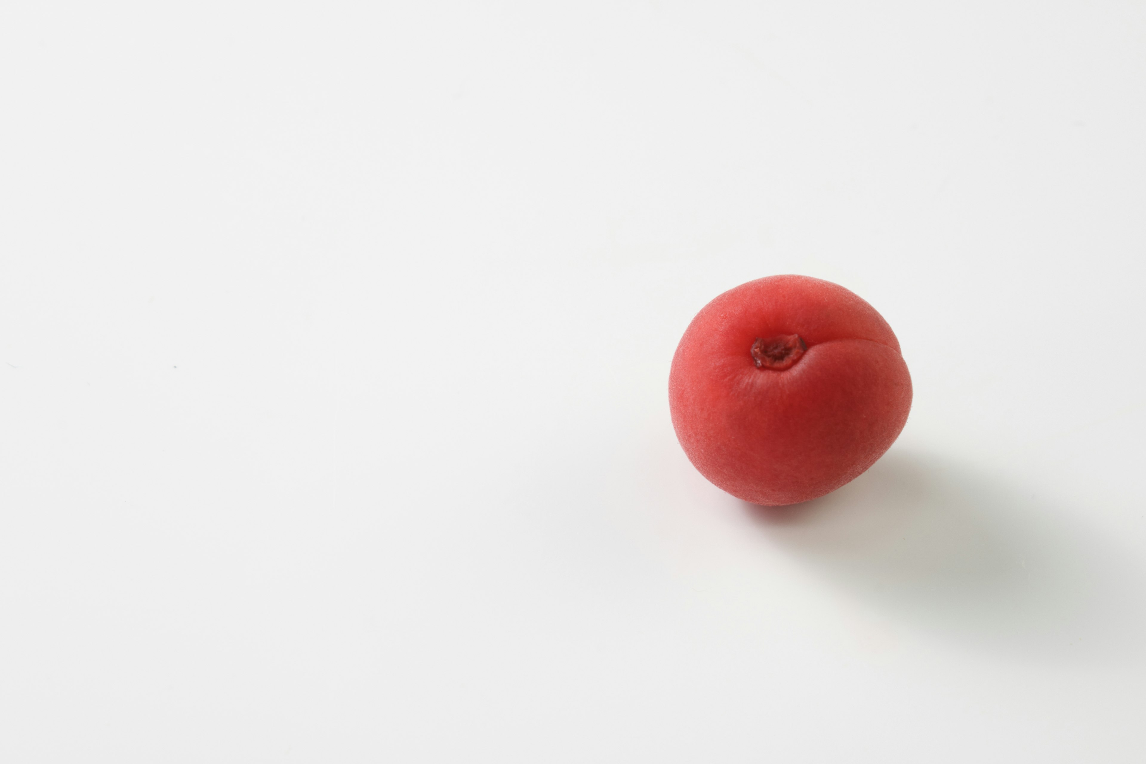 Red fruit-like object on a white background