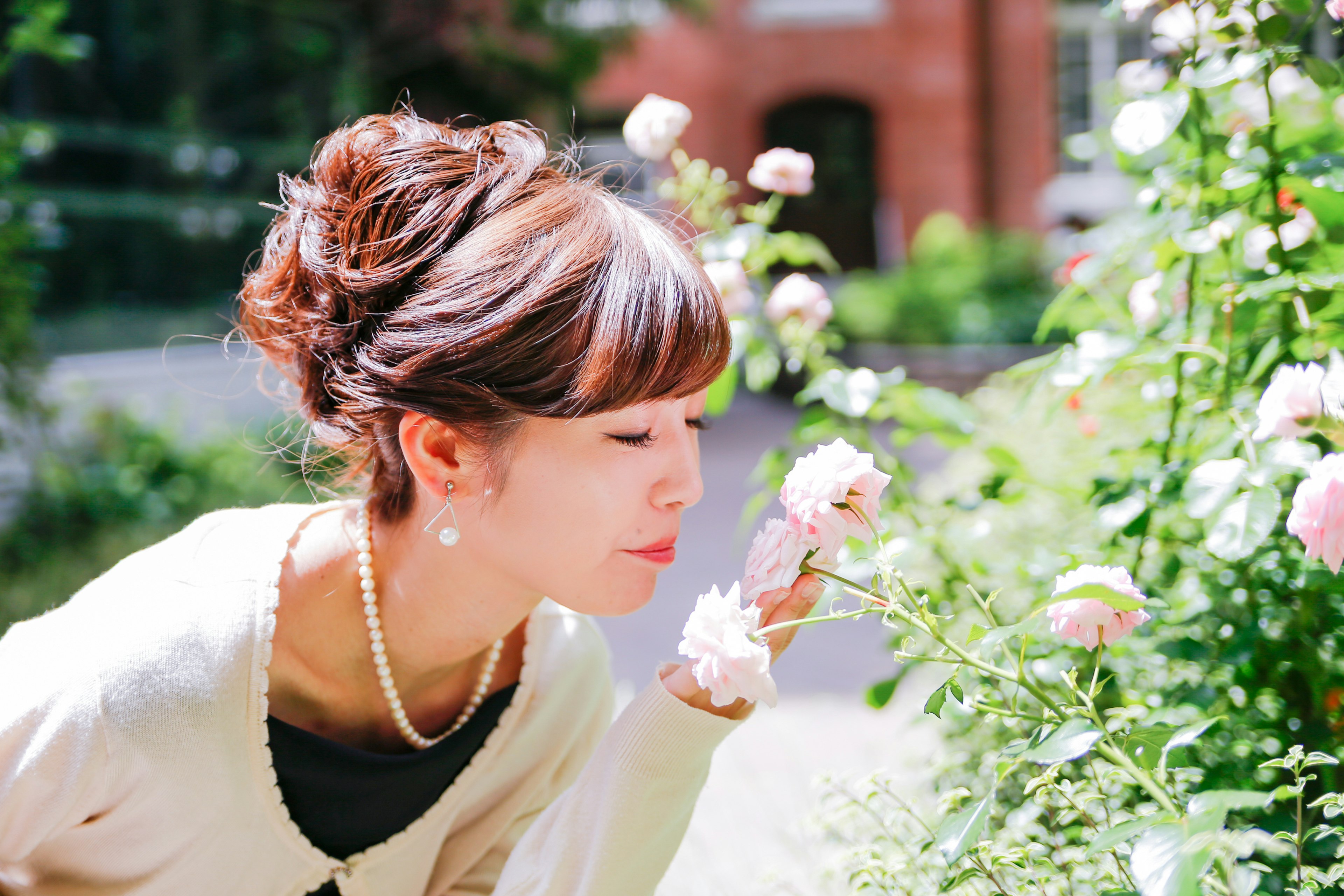 Retrato de una mujer oliendo flores colores suaves y peinado elegante