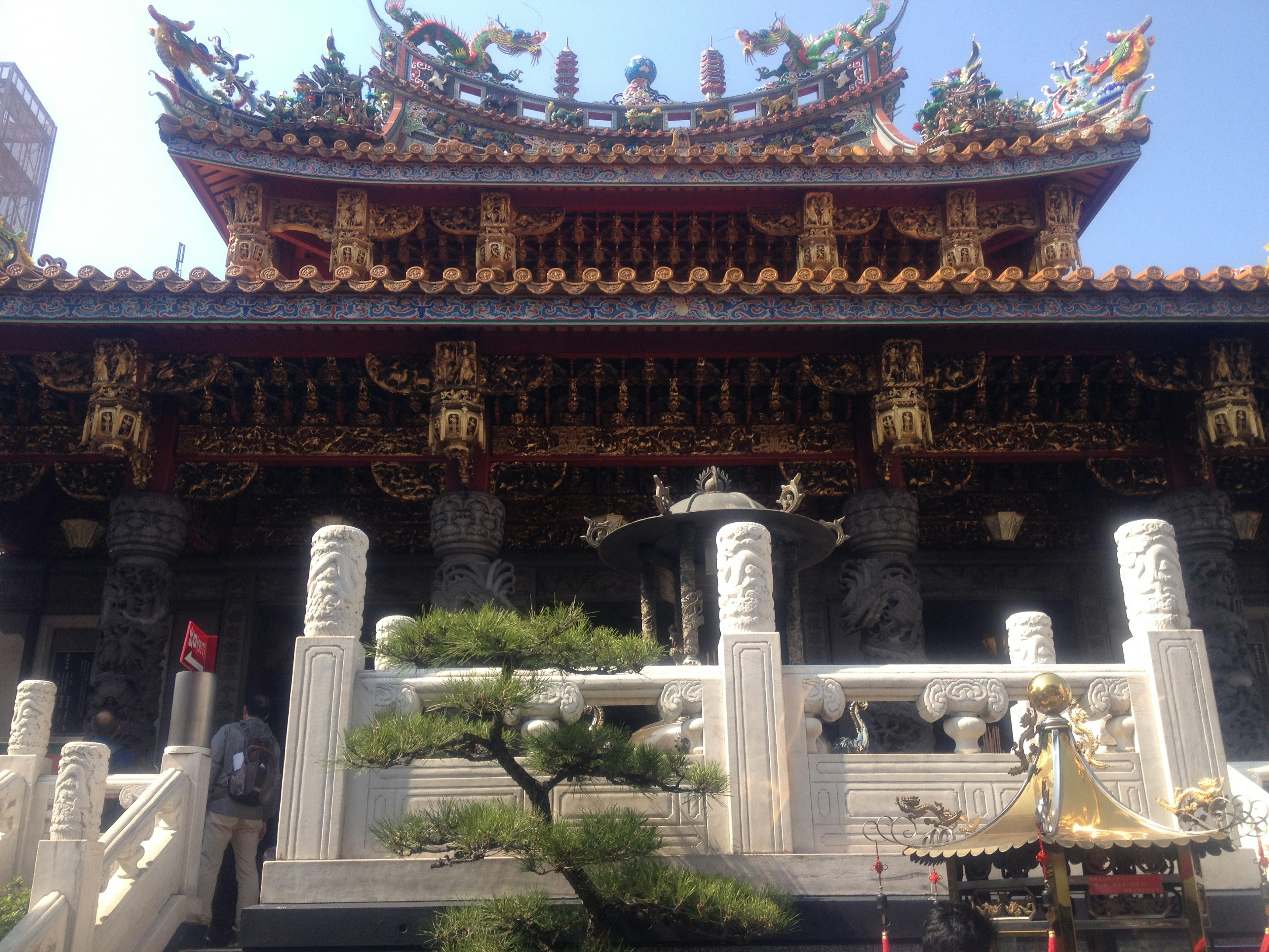 Traditional Chinese temple architecture featuring intricate decorations and a serene garden