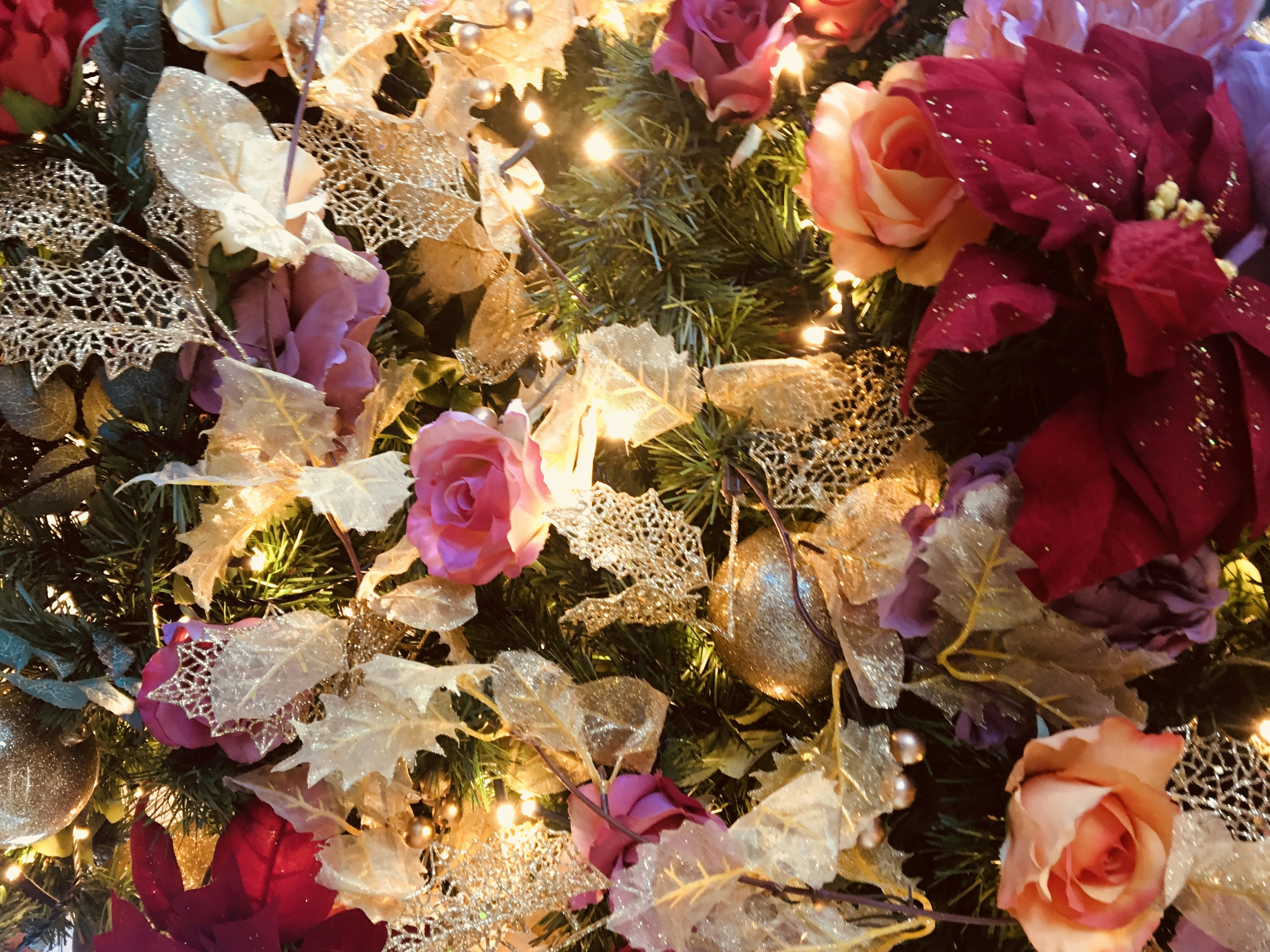 Decorative arrangement of colorful flowers and lights on a Christmas tree