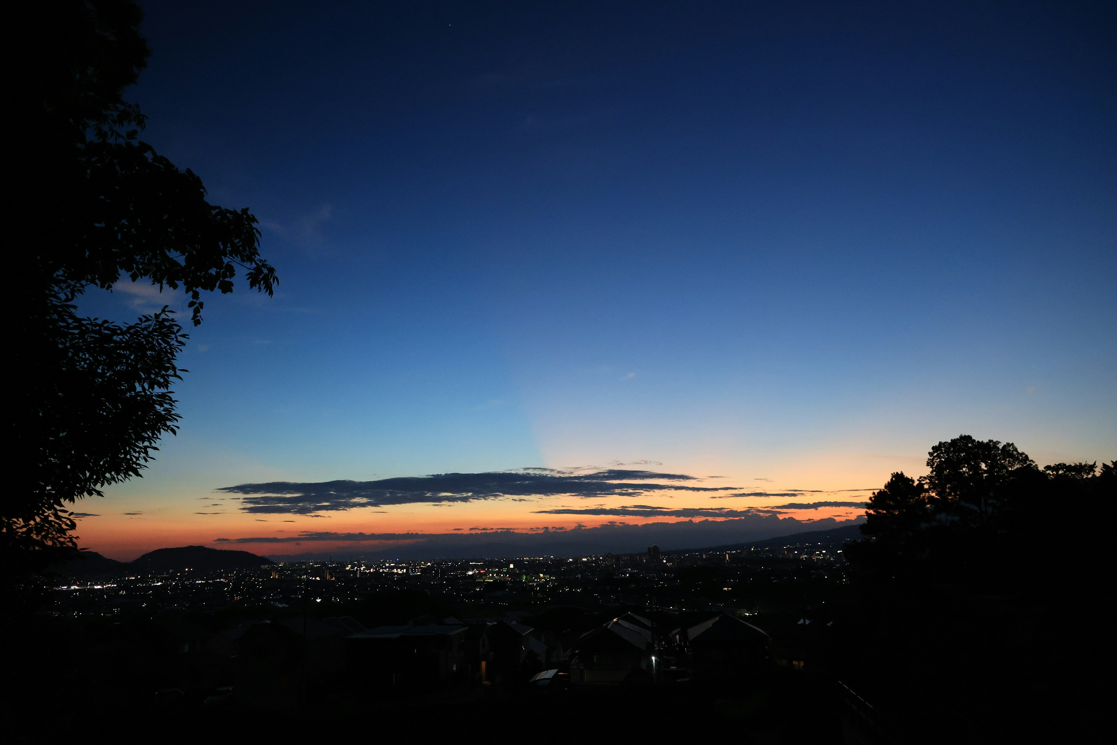 Vista del atardecer con luces de la ciudad