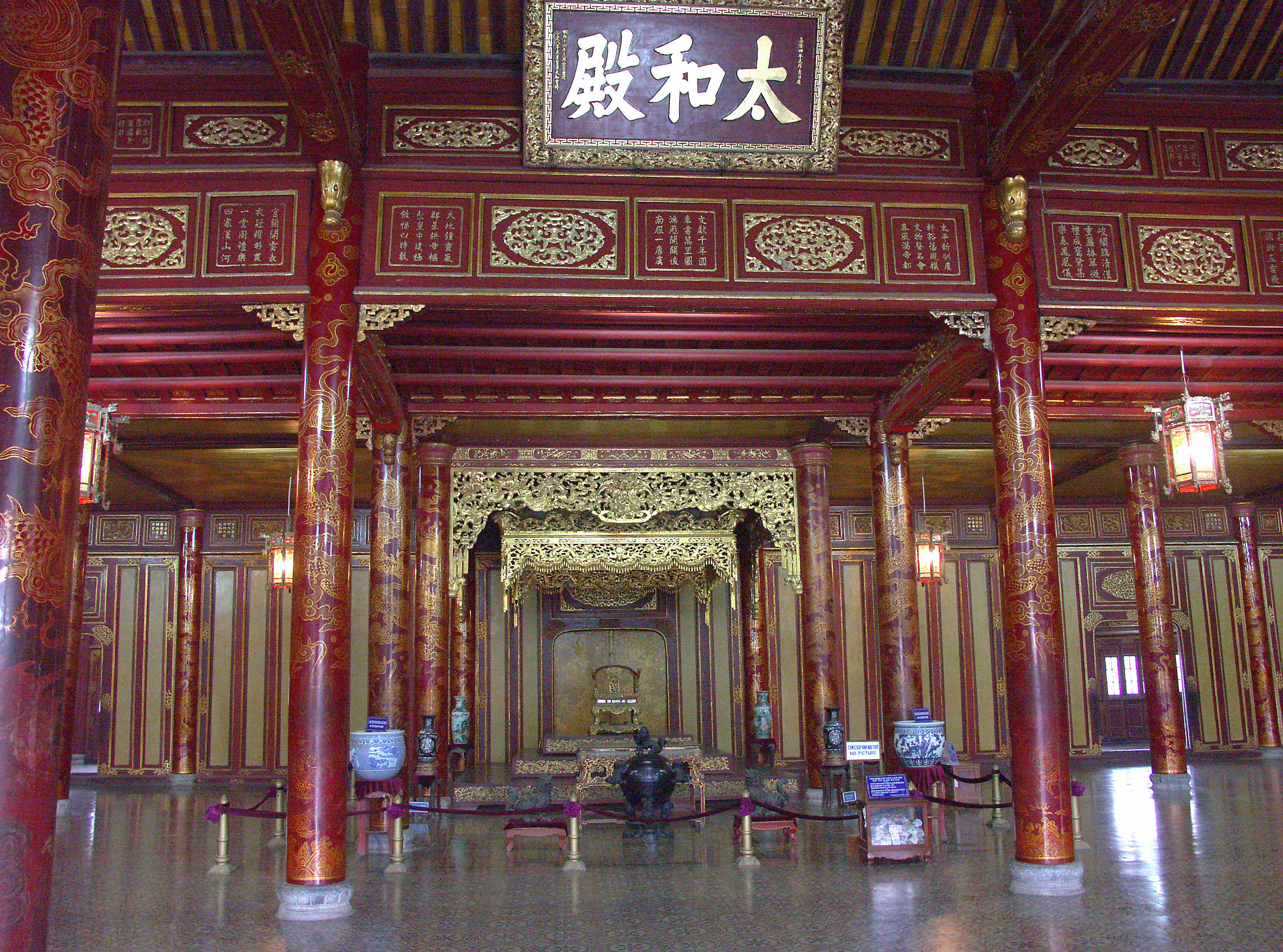 Intérieur d'un bâtiment chinois traditionnel avec des décorations ornées de grands piliers et un trône central