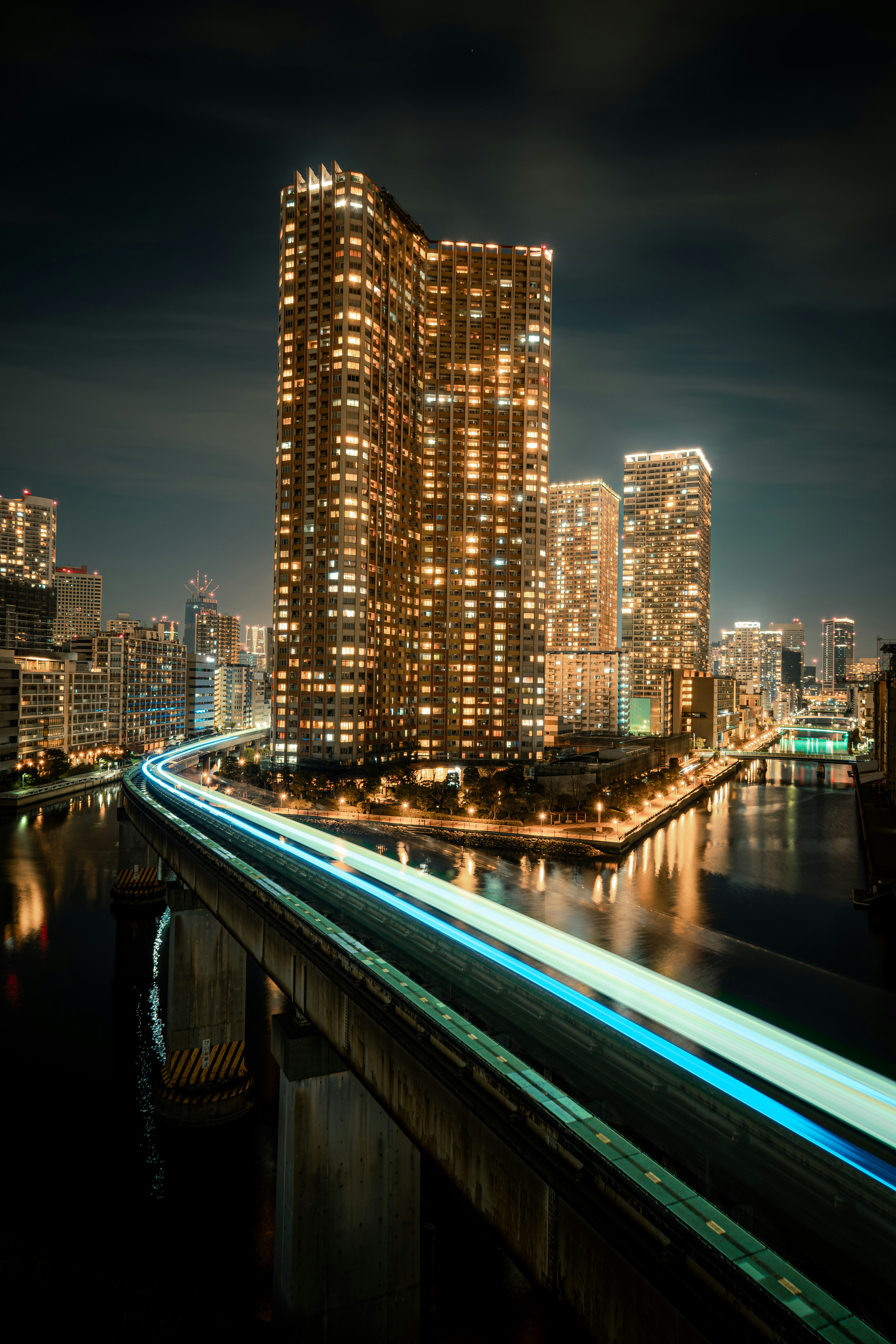 Paysage urbain nocturne avec des gratte-ciels illuminés et une traînée lumineuse