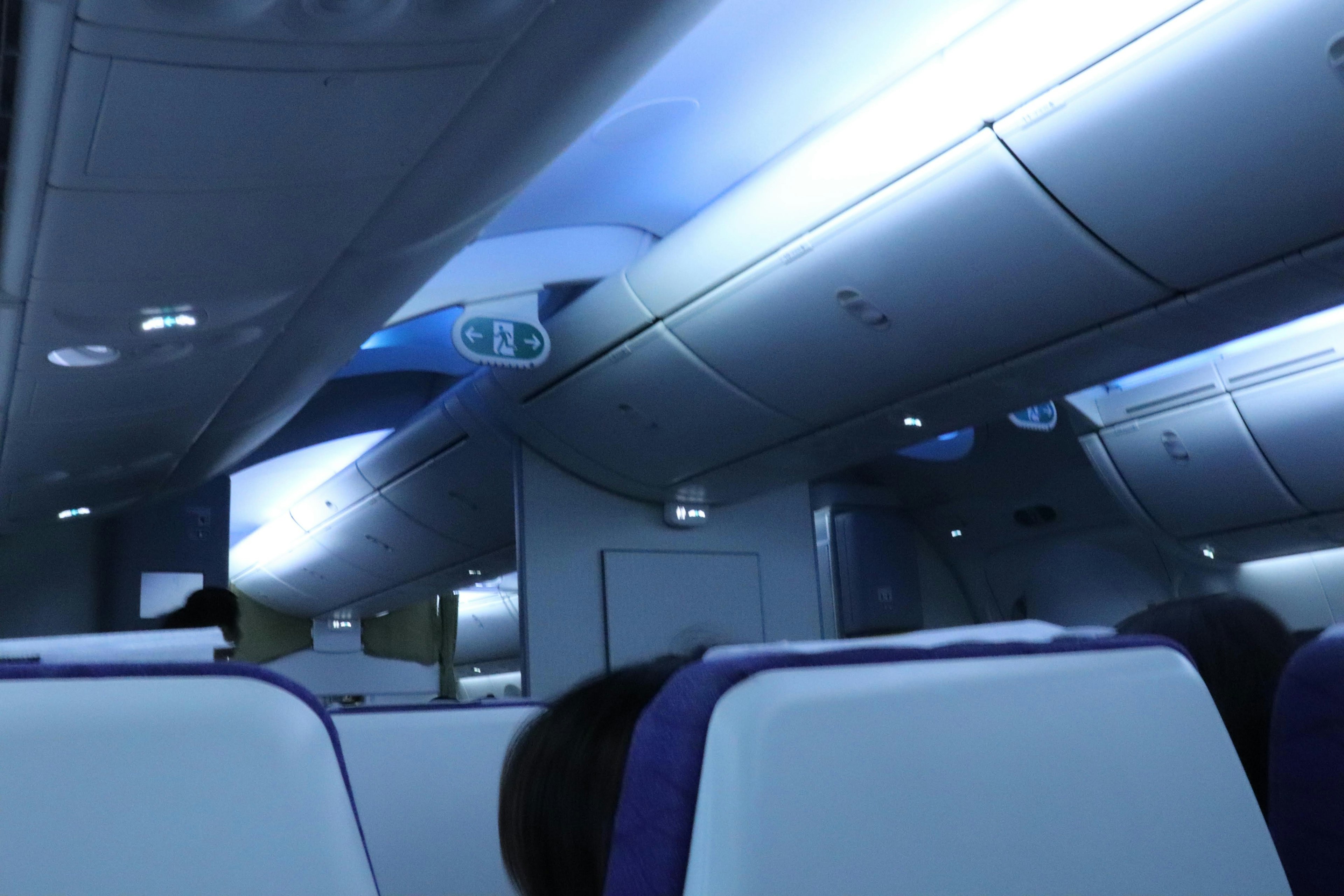 Intérieur d'un avion avec un éclairage bleu vif sièges blancs et violets