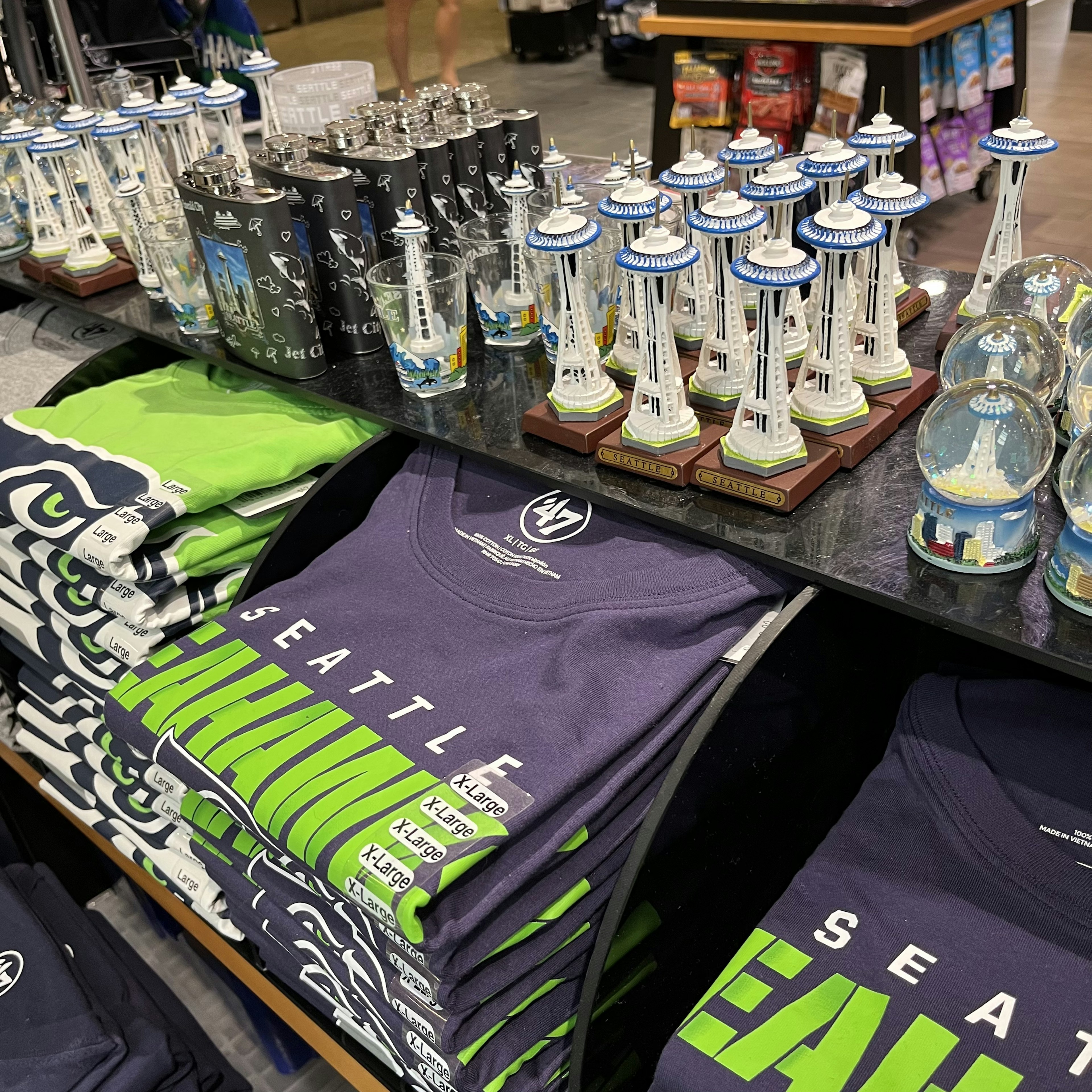 Interior view of a souvenir shop featuring Seattle-themed merchandise including t-shirts and miniatures of landmarks