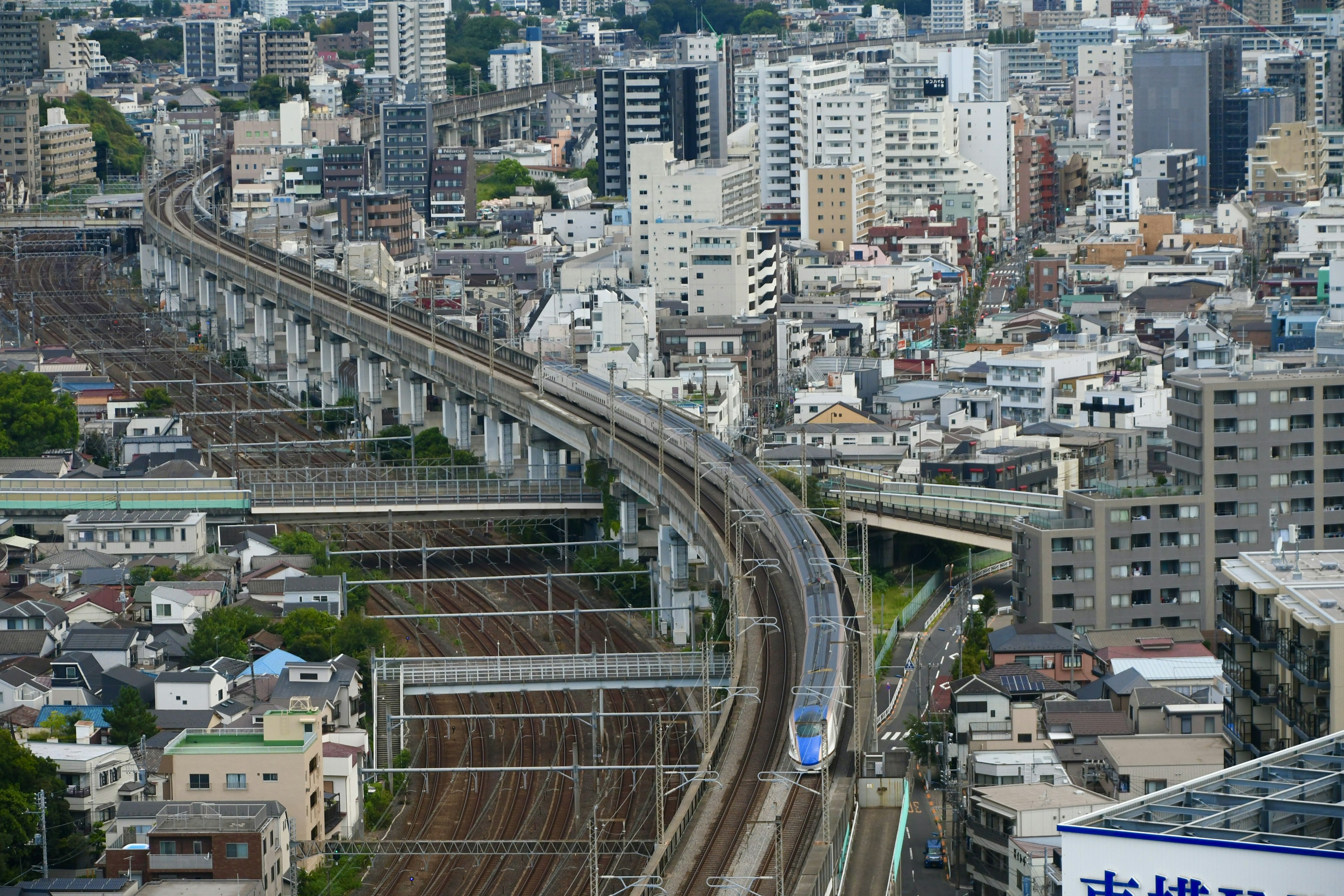 มุมมองทางอากาศของรางรถไฟสูงและอาคารในเมืองรอบข้าง