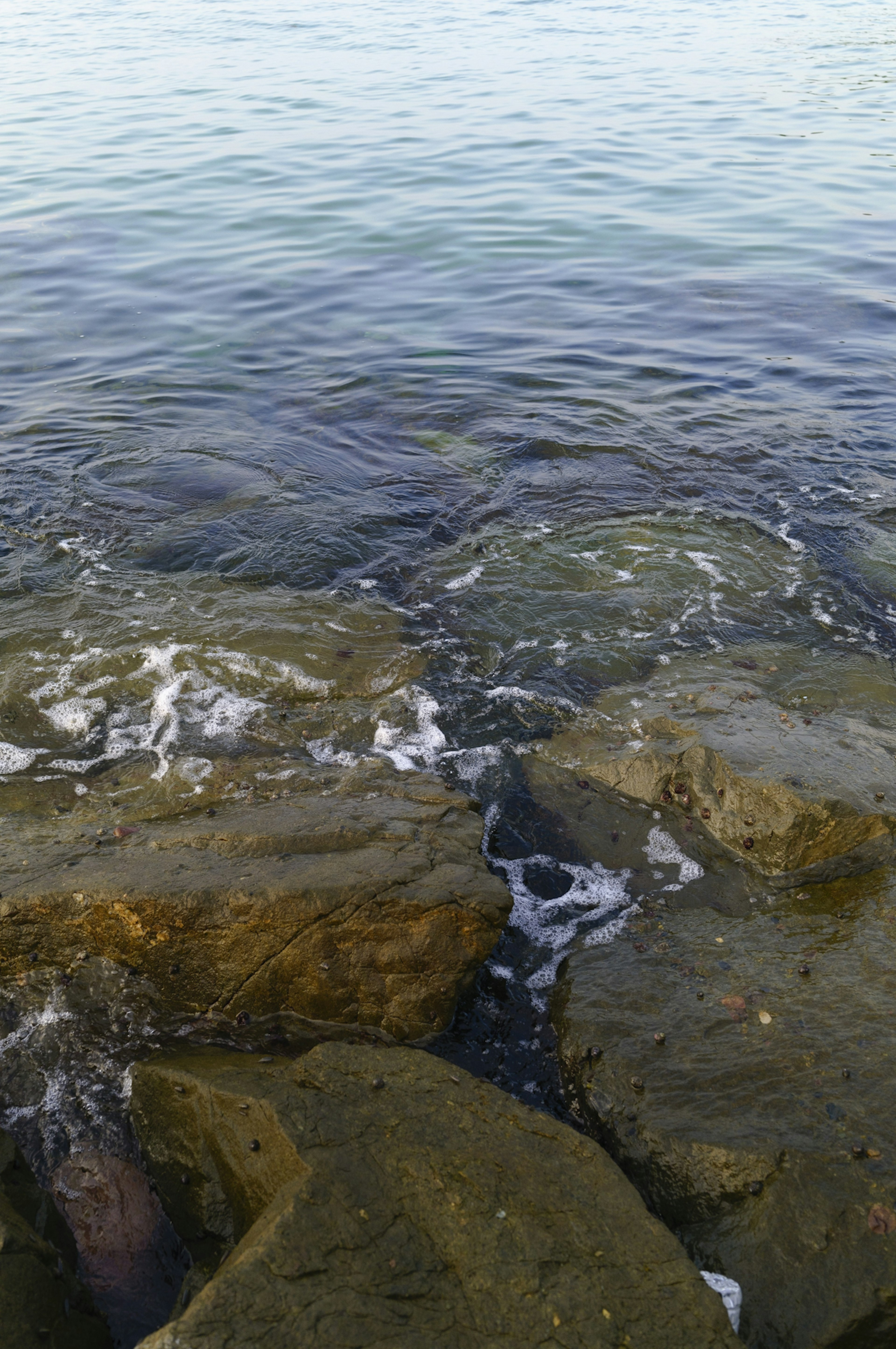 Waves crashing against rocks in a serene coastal setting